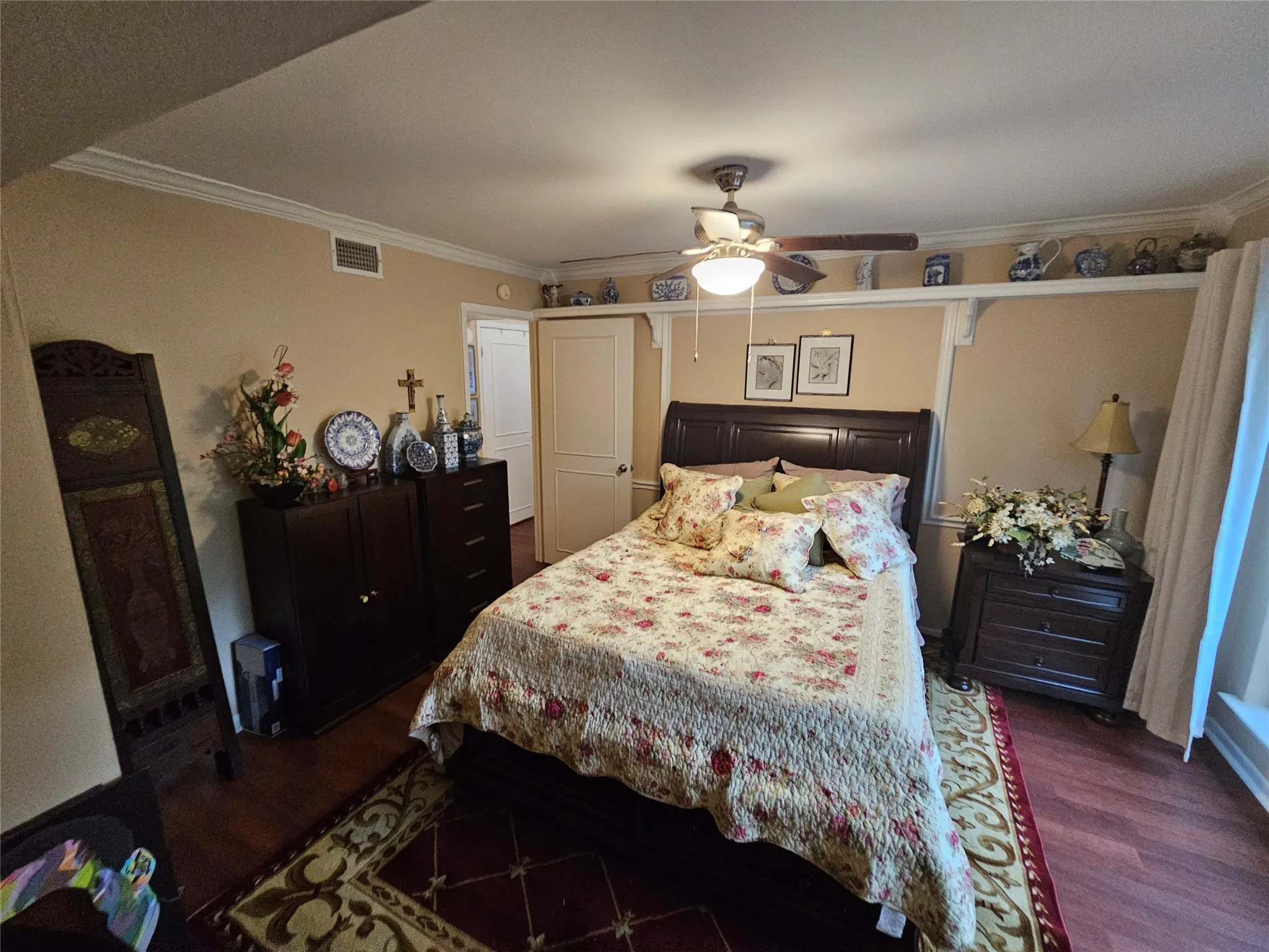 Wood look flooring throughout home complemented by crown molding and a ceiling fan with integrated lighting