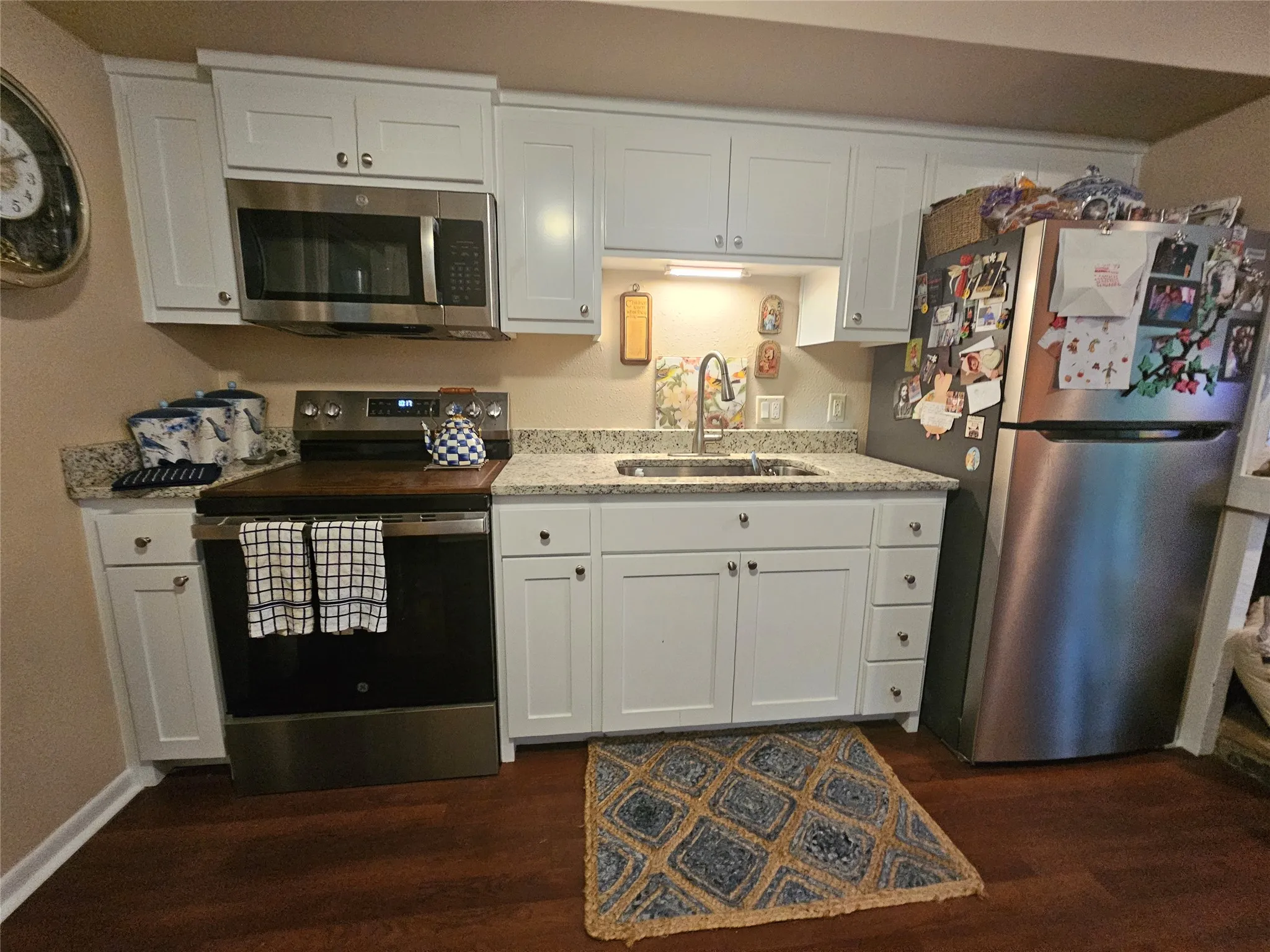 Kitchen featuring white cabinetry, stainless steel appliances & built in microwave