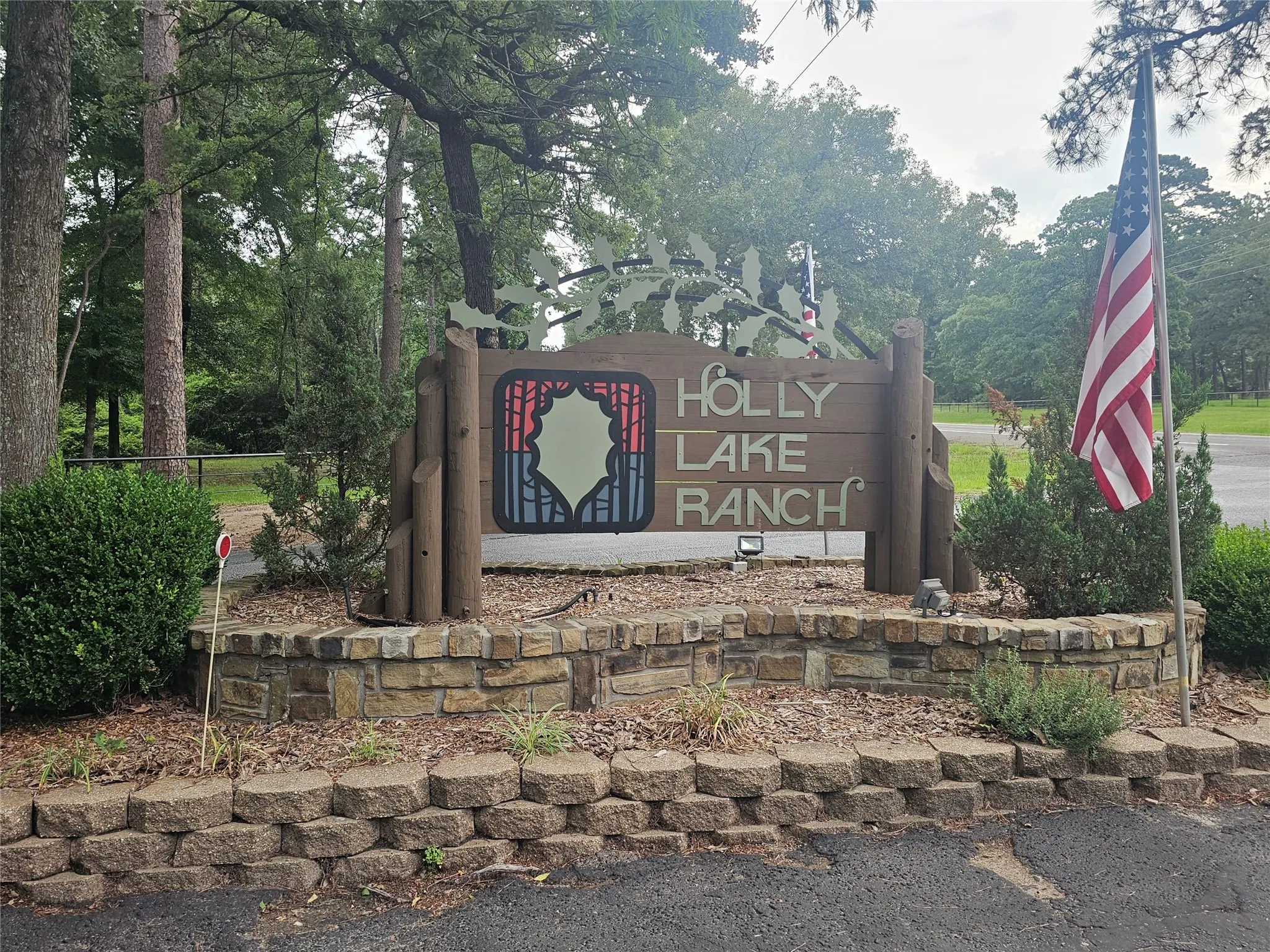 Stone-faced signage for Holly Lake Ranch featuring a custom design and integrated landscaping