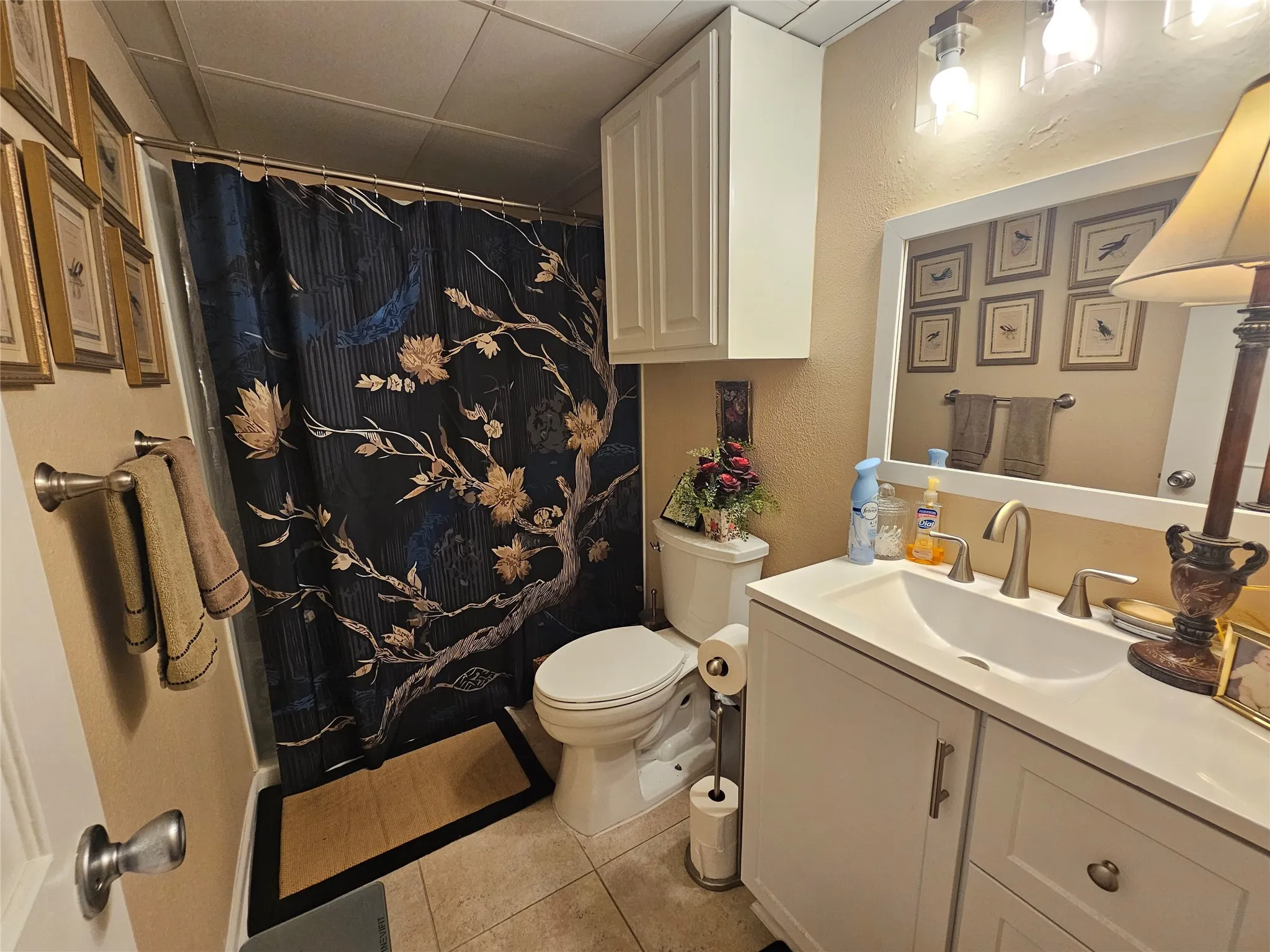 Bathroom featuring a white vanity with an integrated sink, brushed nickel faucet, and a large framed mirror