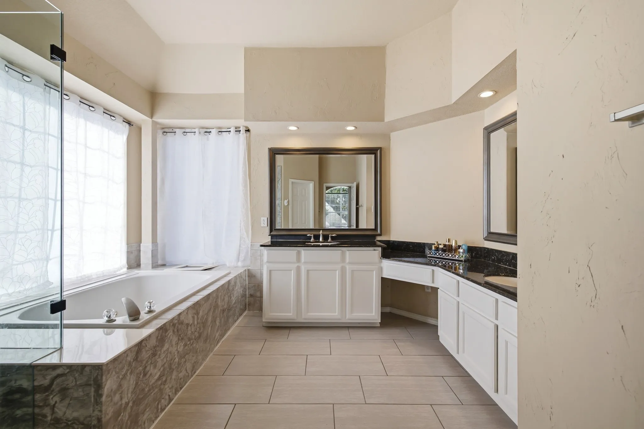 Ensuite bathroom remodeled with new shower tile, tub surround and 12x24 floor tiles.