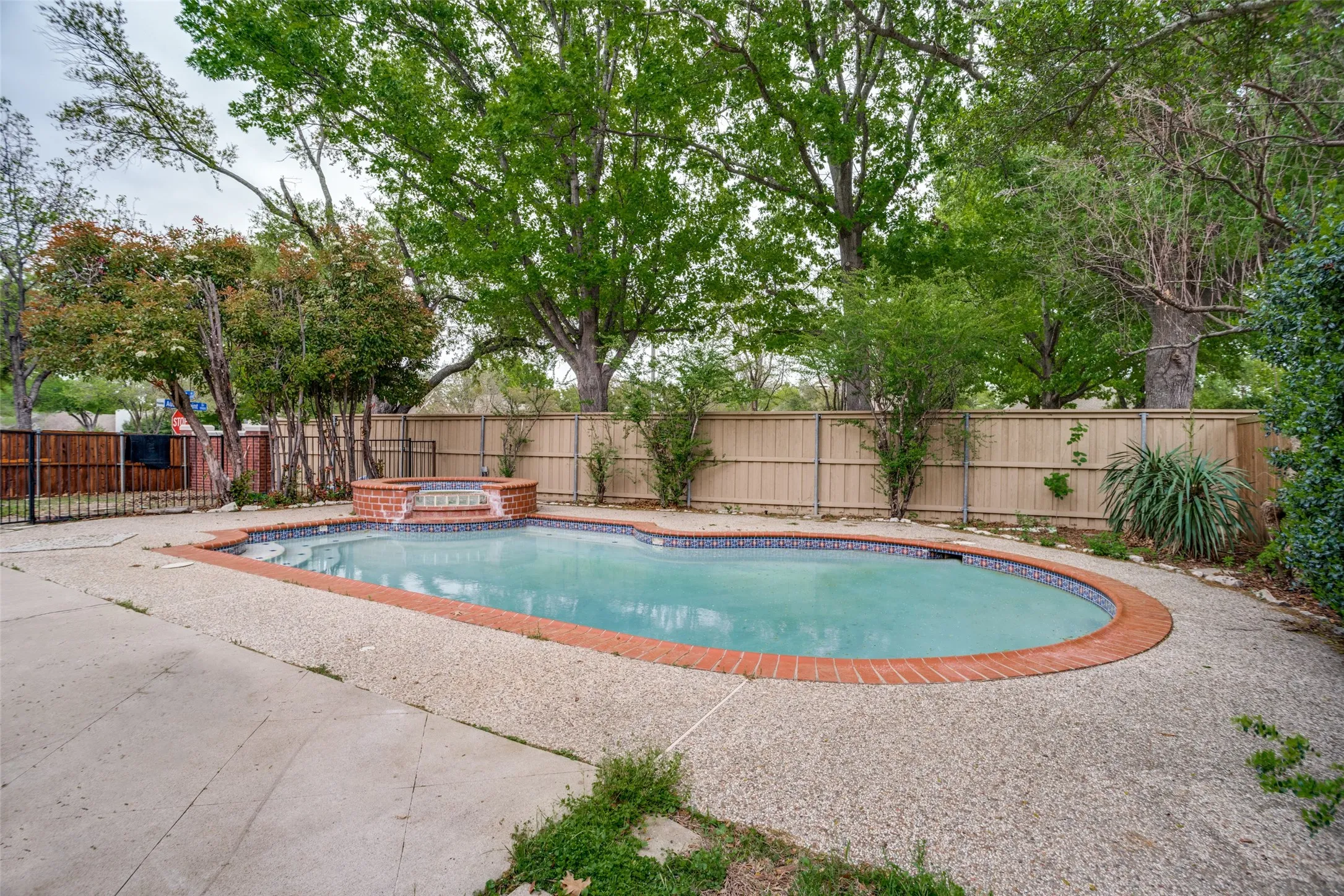Combined pool / hot tub featuring a fenced backyard and a patio area