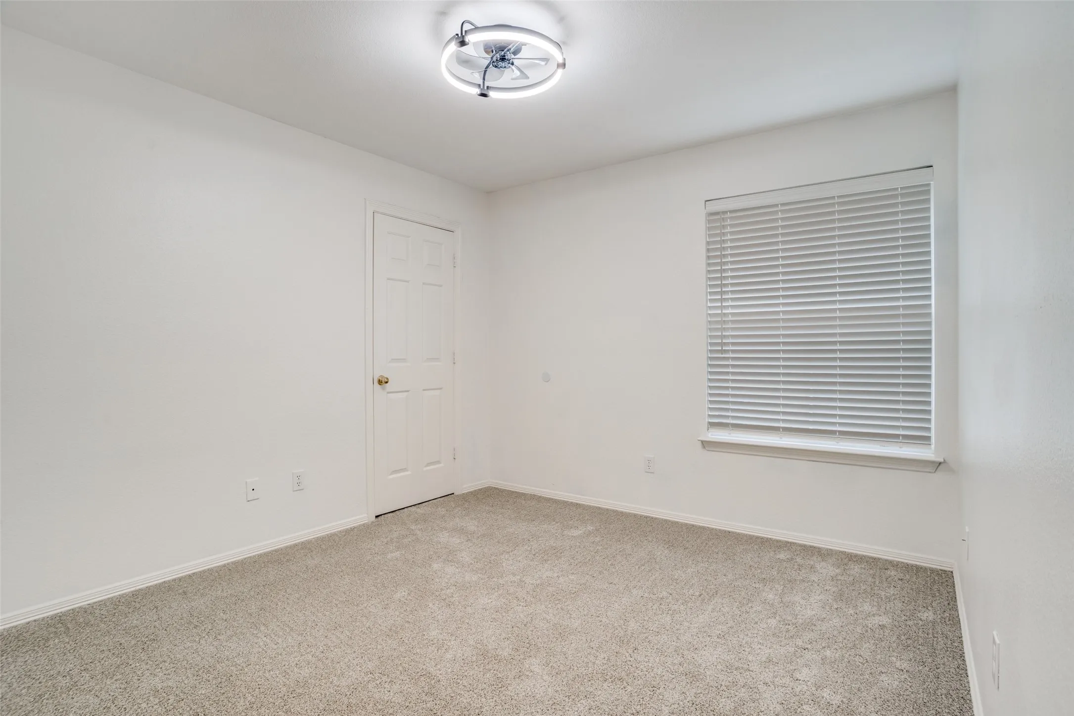 Spare room featuring baseboards and light colored carpet
