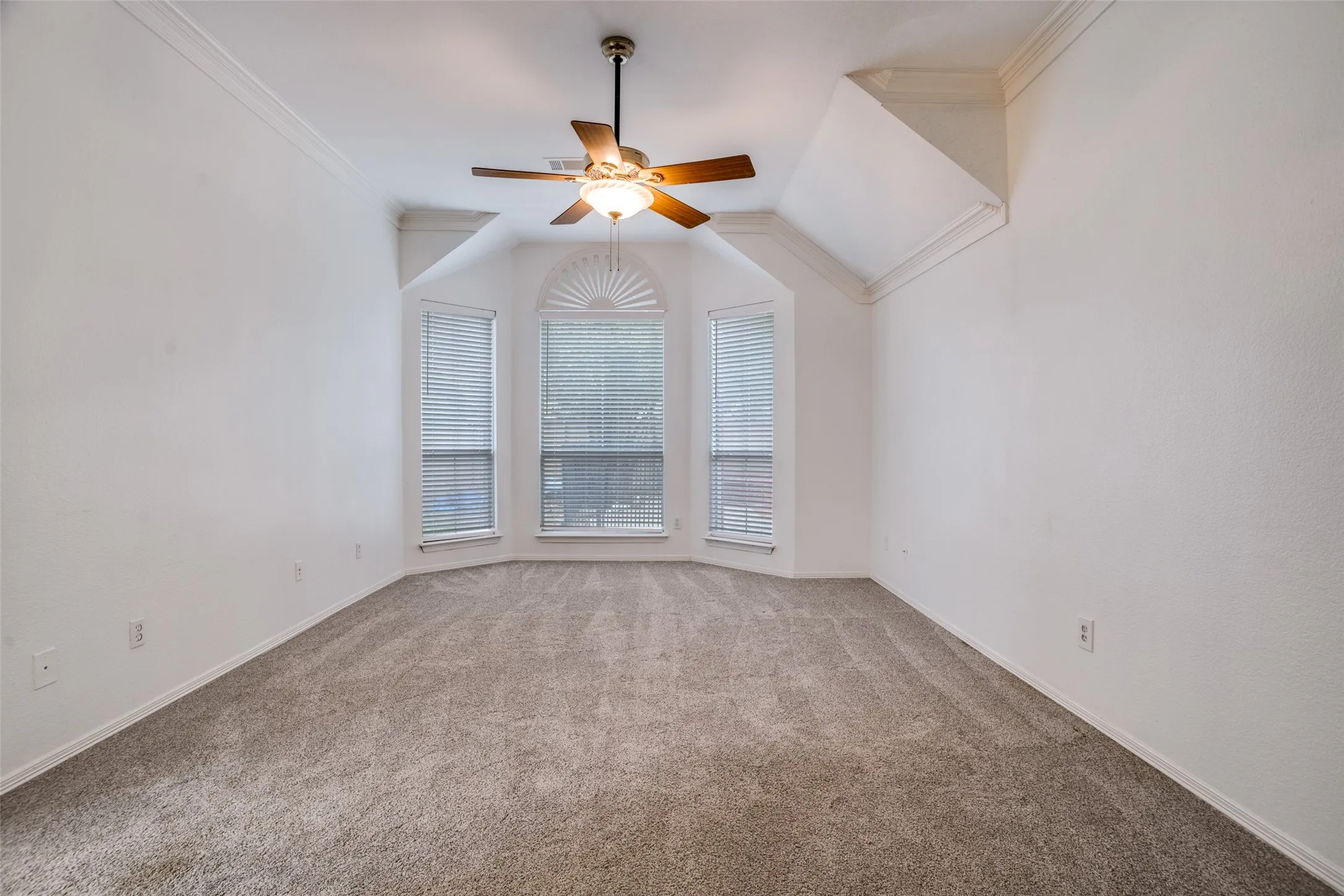 Carpeted empty room with ceiling fan and crown molding
