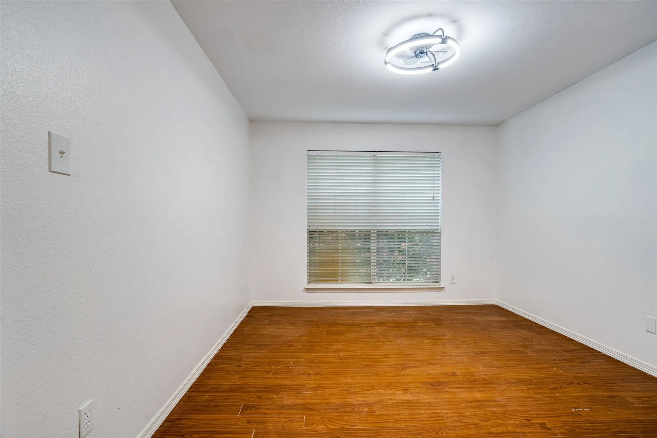 Unfurnished room featuring baseboards and dark wood-style floors