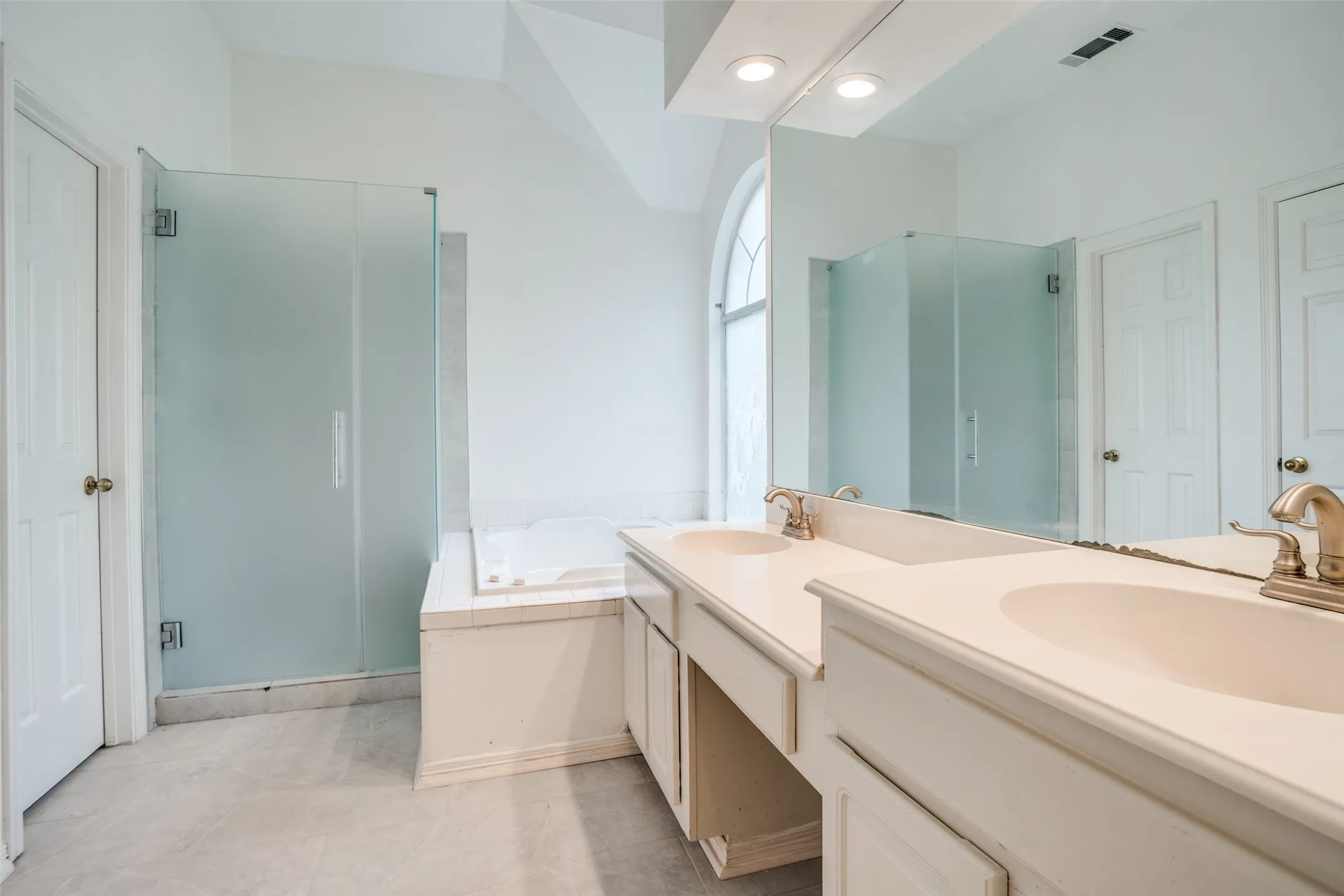 Full bathroom with a stall shower, double vanity, and a garden tub