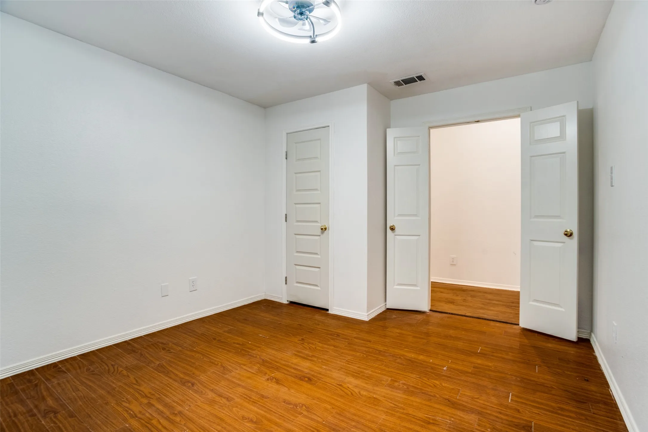 Unfurnished bedroom with dark wood finished floors and baseboards