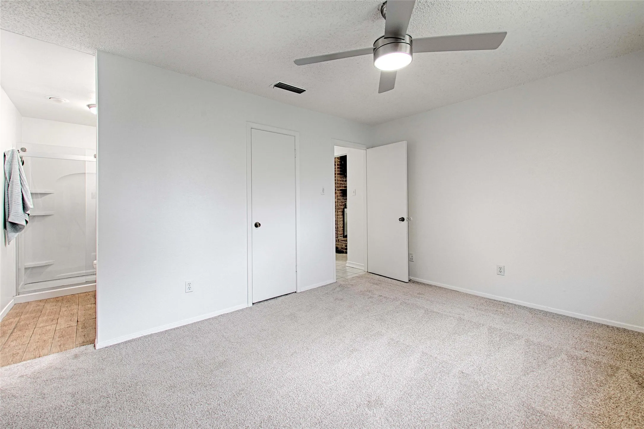 Neutral wall paint and plush carpet flooring in this bedroom