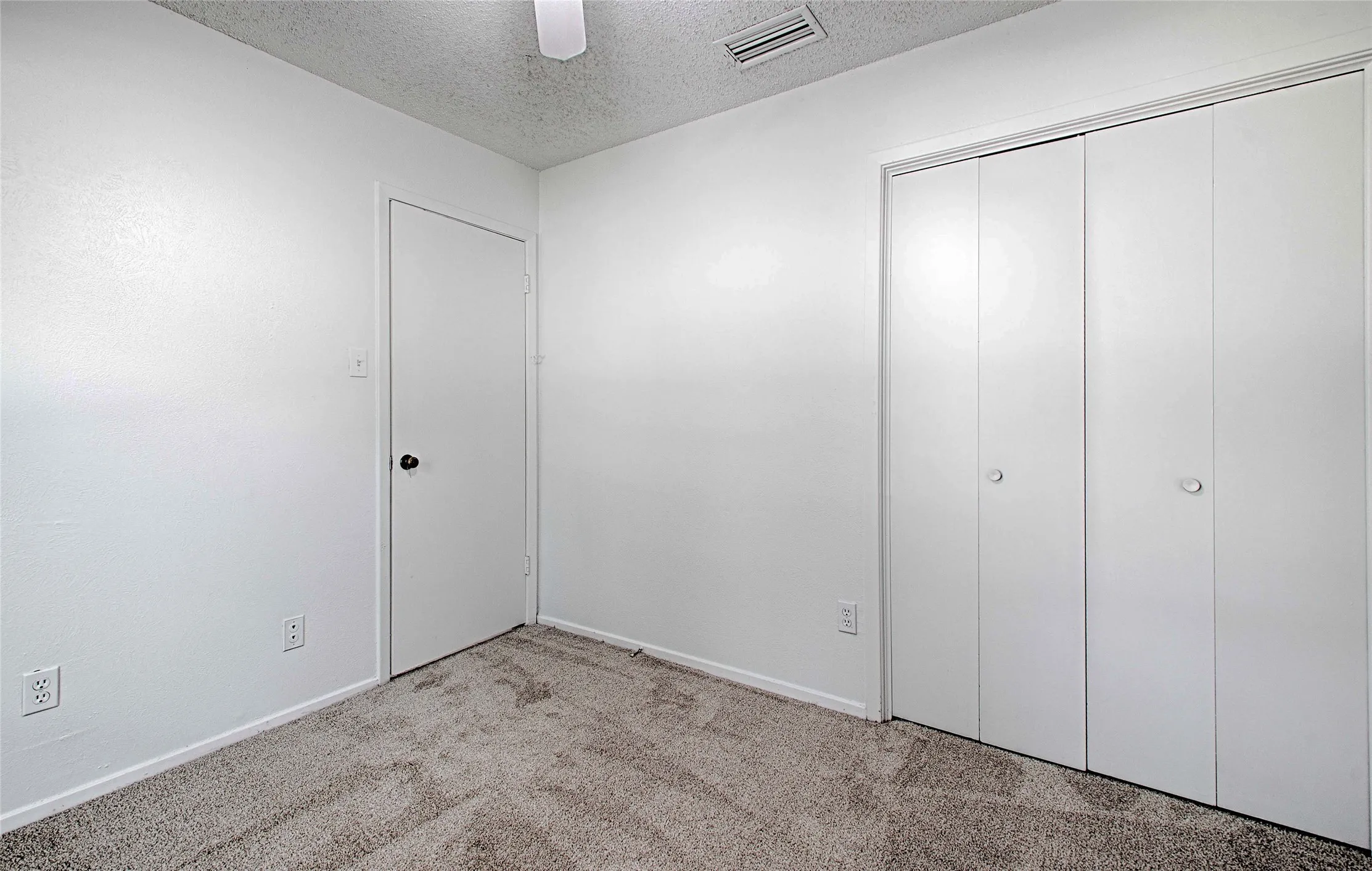 Light-colored carpeted flooring with white walls