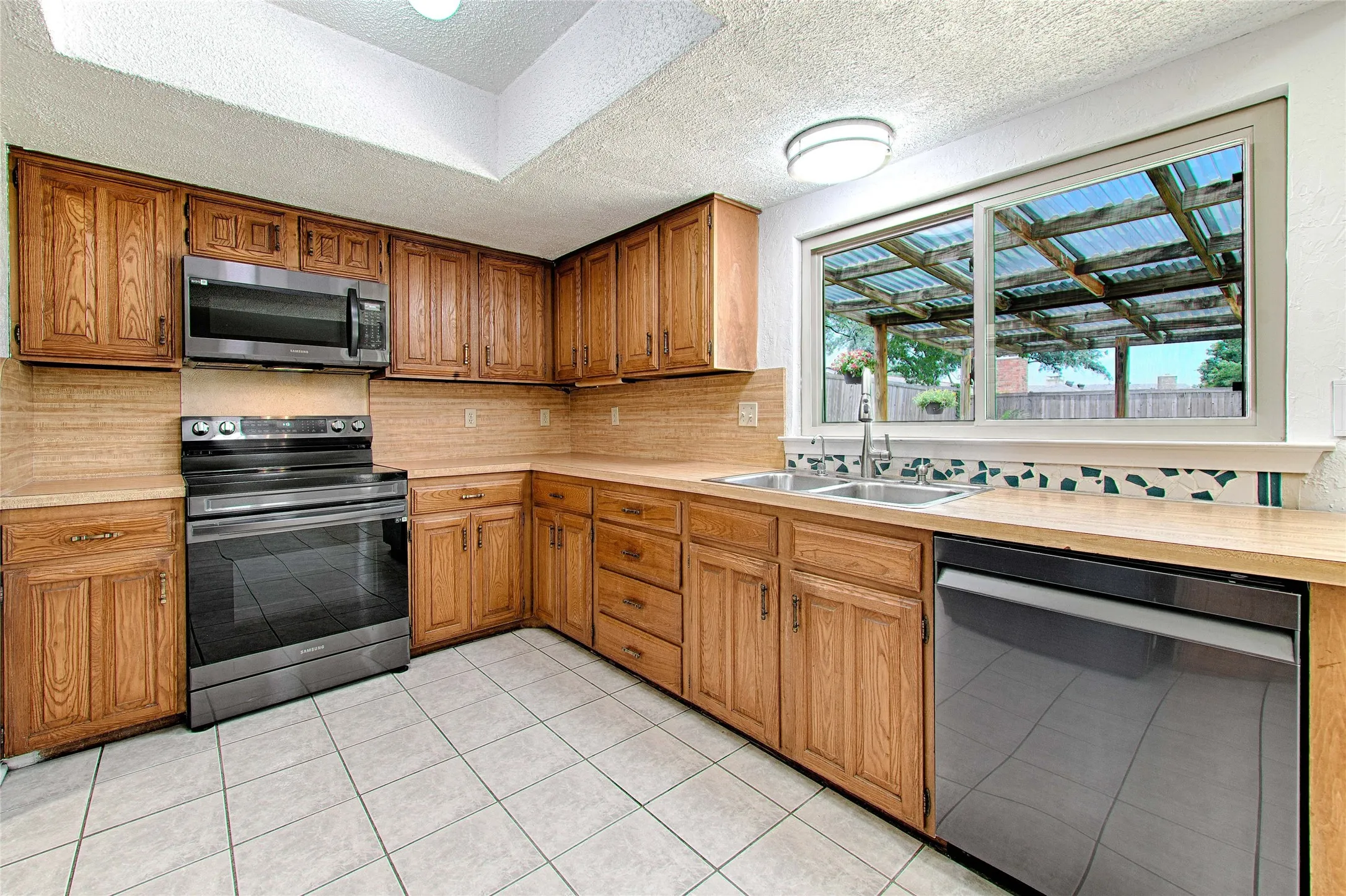 Kitchen featuring wood cabinetry, light countertops, and tile flooring