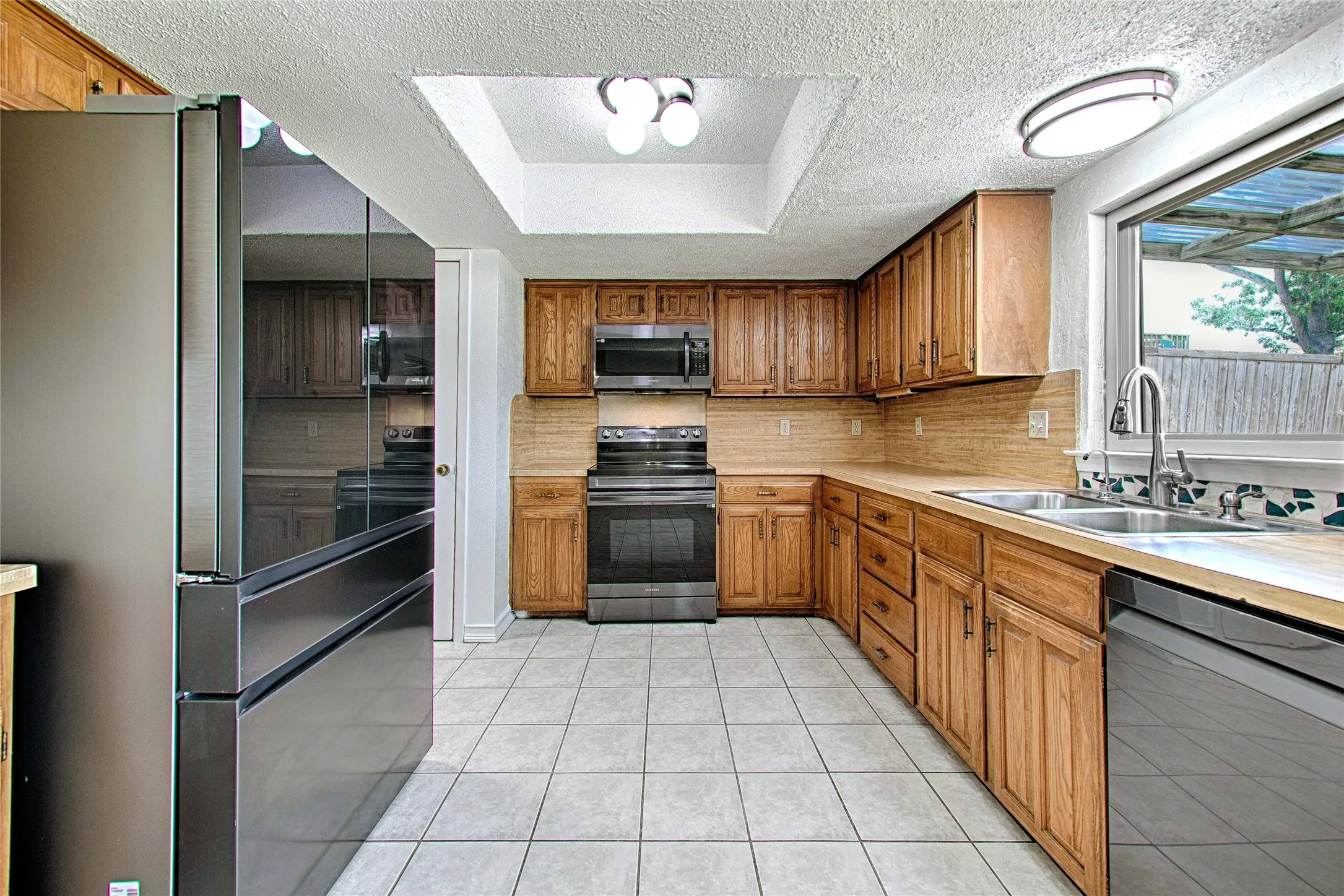 Kitchen featuring wood cabinetry, stainless steel appliances, and a double basin sink