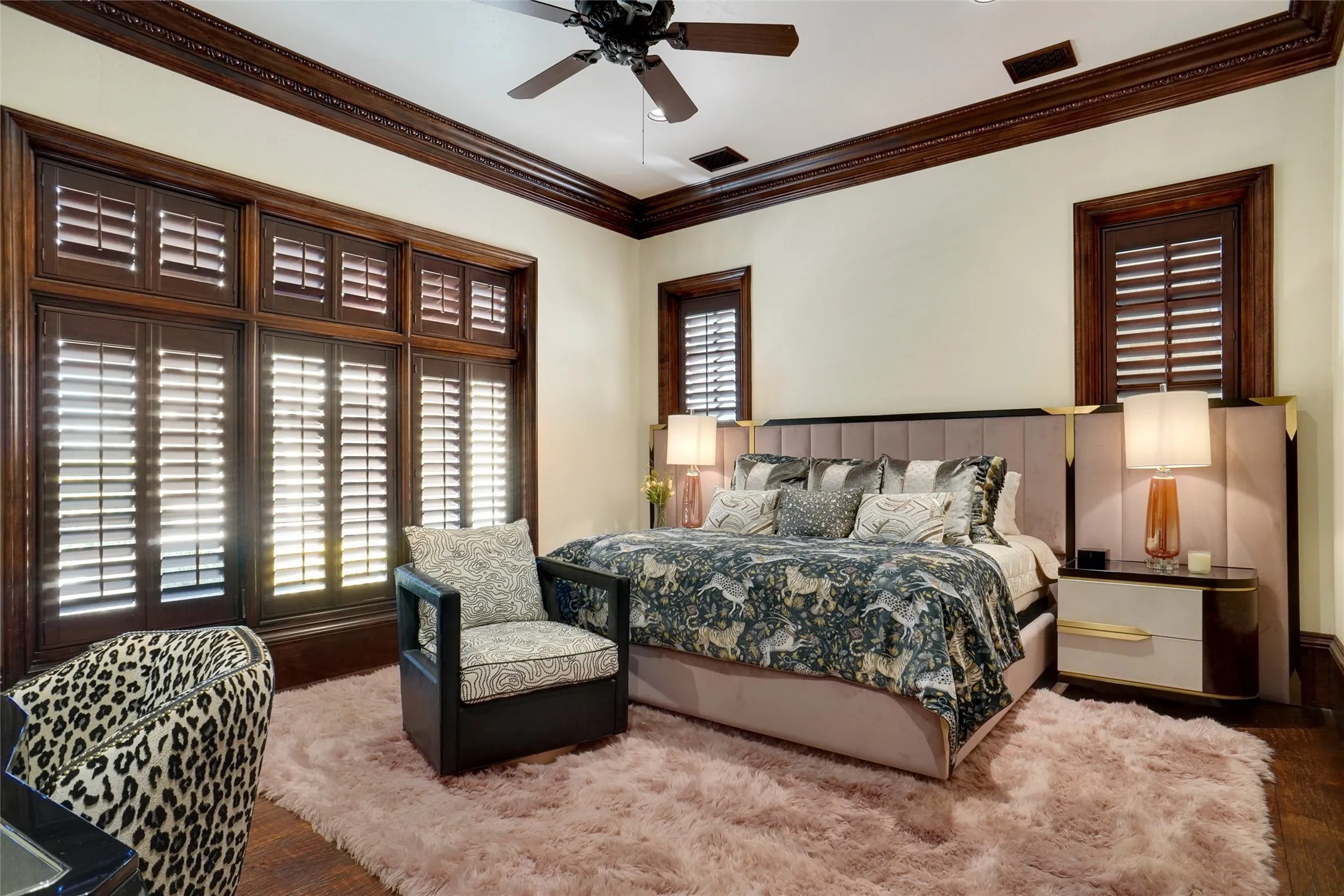 Guest bedroom located on the main level featuring elegant wood-finish trim and crown molding.