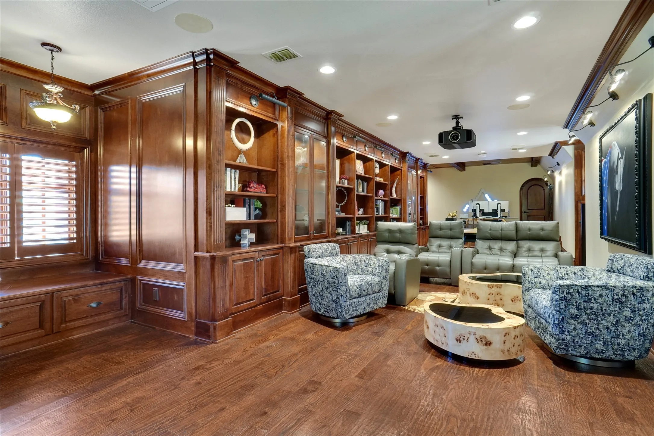 This expansive, well-appointed game room features a dedicated, spacious sitting area designed for ultimate comfort and relaxation. It is fully equipped with high-end AV projection capabilities and a professional-grade motorized screen, creating an immersive cinematic and gaming experience perfect for hosting guests or enjoying quiet evenings at home.