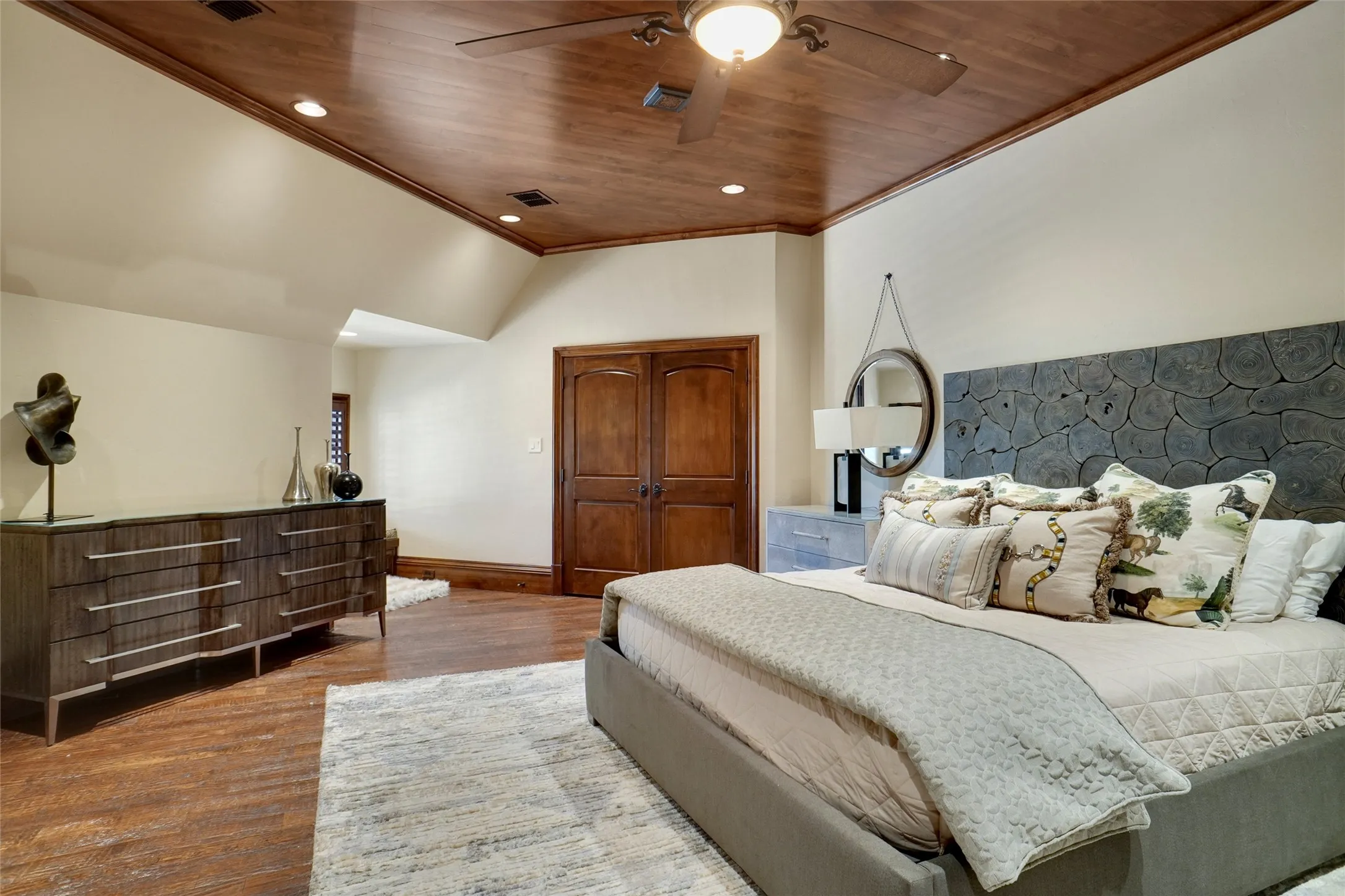 Spacious bedroom featuring a beautiful wood-finish ceiling, modern recessed lighting, and a ceiling fan, situated in the second residence.