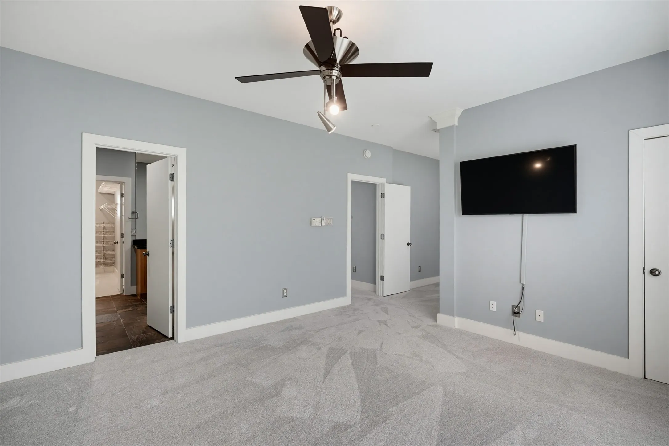 Light-colored carpeting with a contemporary ceiling fan and recessed lighting