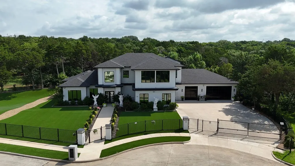 Contemporary residence featuring a white exterior with dark trim and a black roof