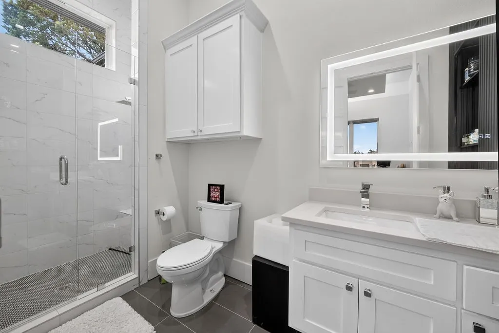 Modern bathroom featuring a glass-enclosed shower with large format tile surround and penny tile flooring