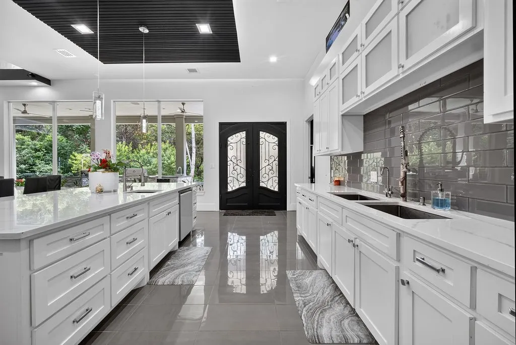 Spacious kitchen featuring white cabinetry, light countertops, and a gray subway tile backsplash