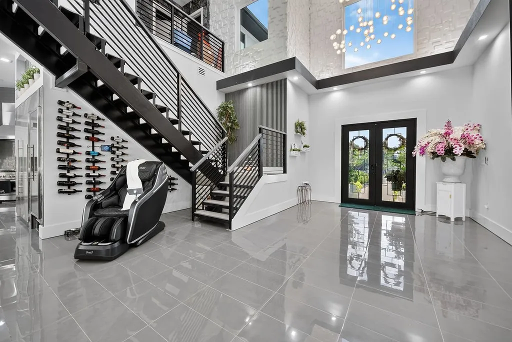 Grand foyer featuring a contemporary staircase with dark wood treads and metal railings