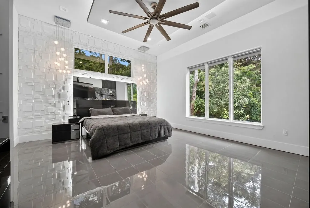 Spacious room featuring glossy tile flooring, a recessed ceiling with a large ceiling fan, and extensive windowing