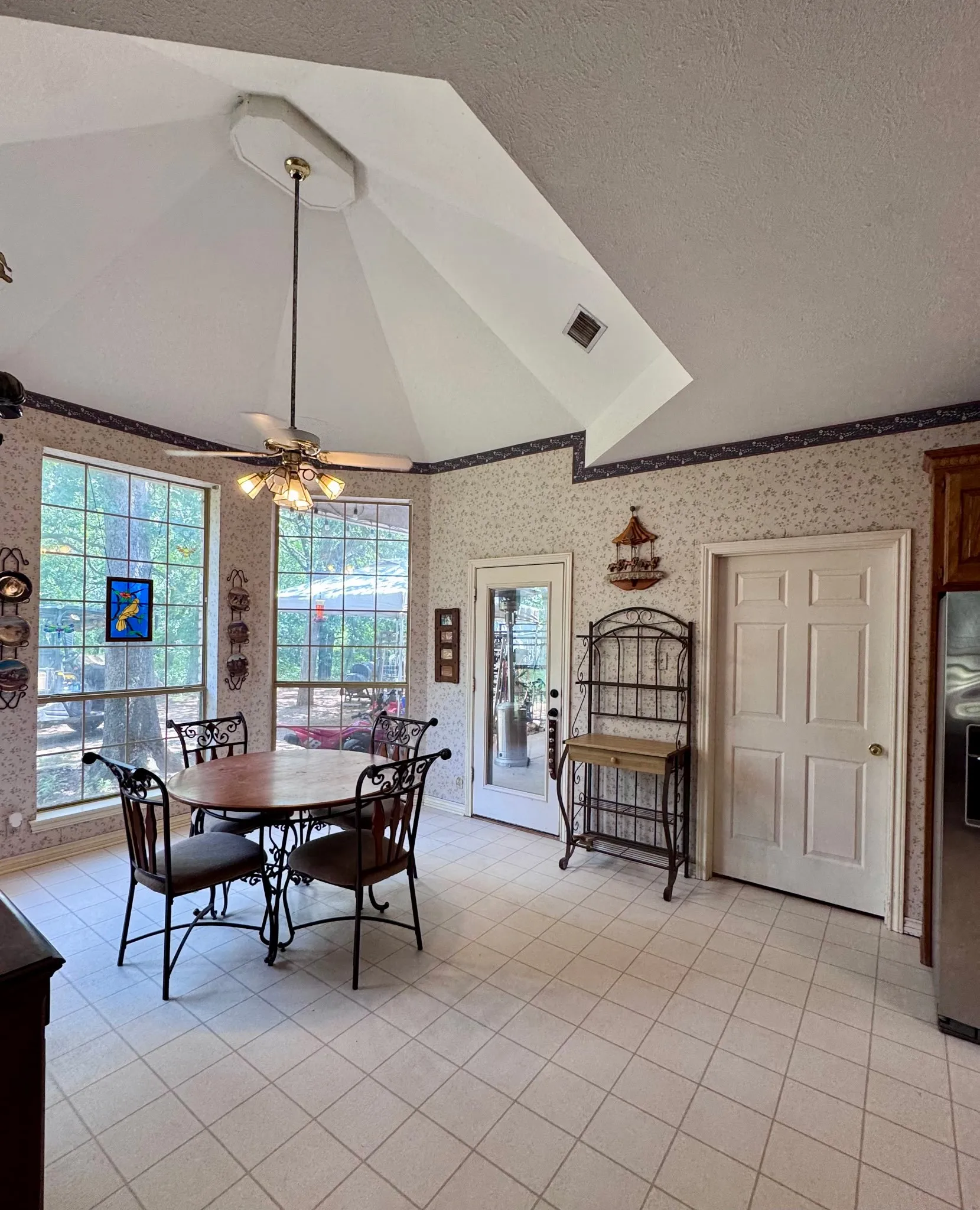 Spacious coffee nook featuring a vaulted ceiling and large windows to view nature.