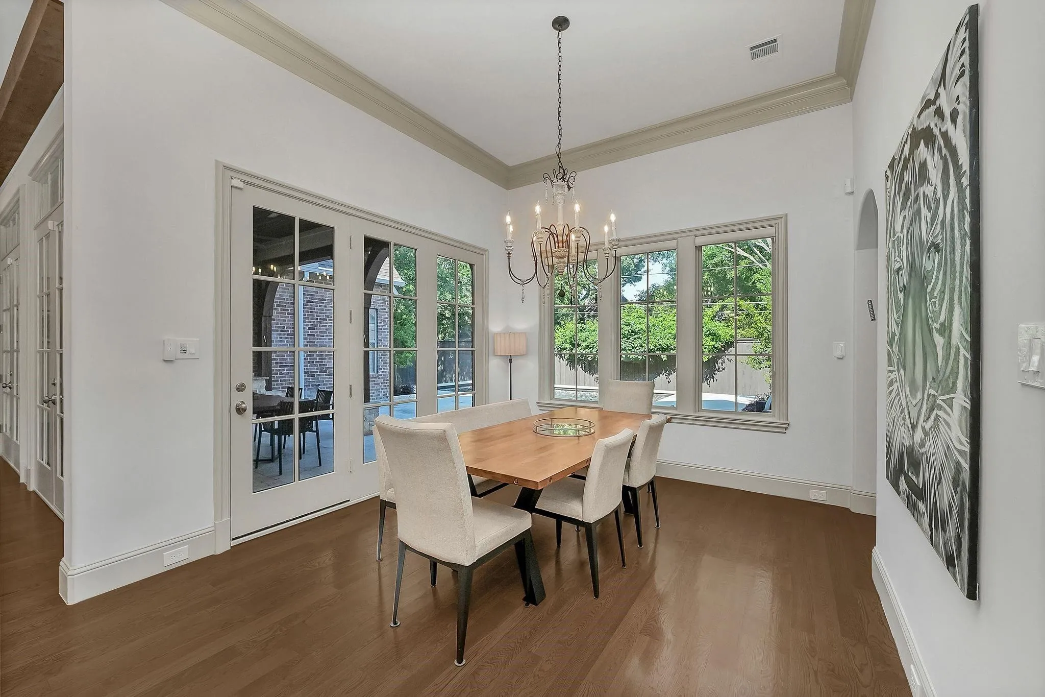 Dining area featuring wood-finish flooring, a wrought iron chandelier, and white French doors