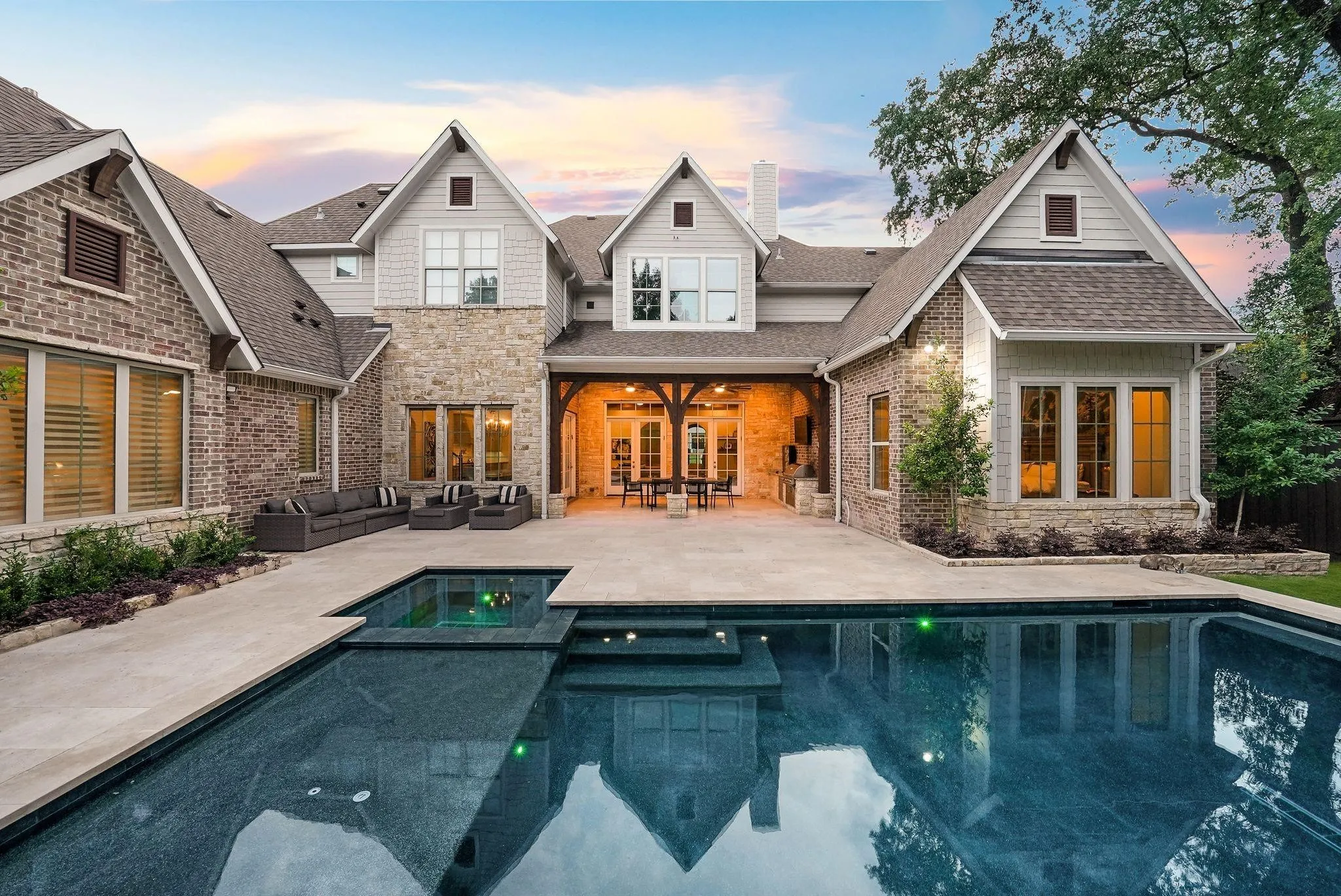 Stunning multi-story residence featuring a brick and stone facade with gabled rooflines