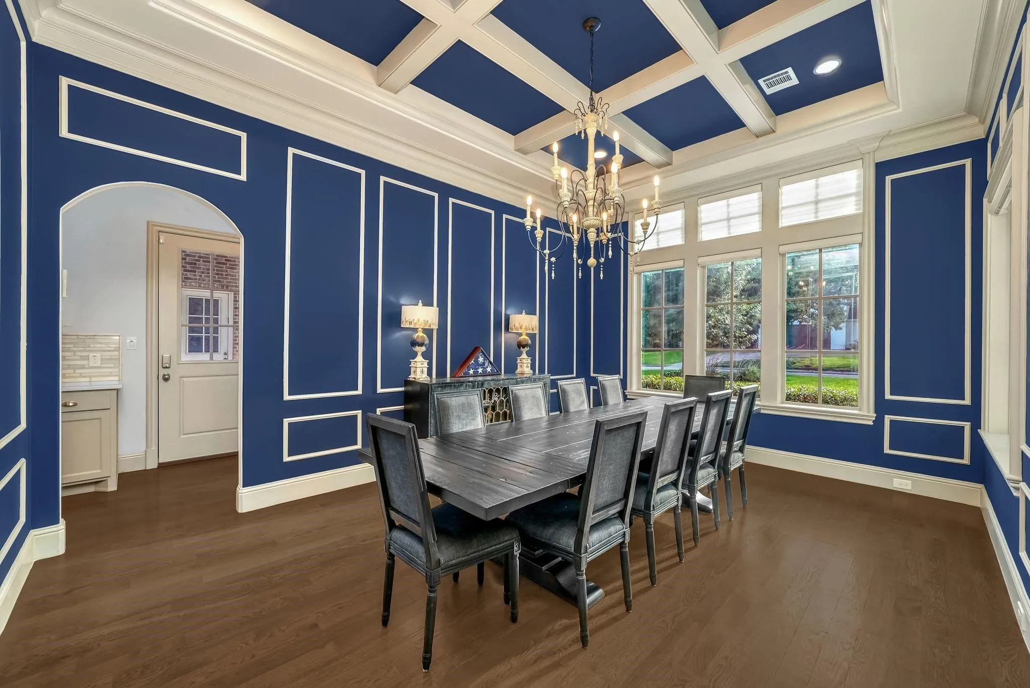 Formal dining room featuring extensive wainscoting and crown molding on blue walls