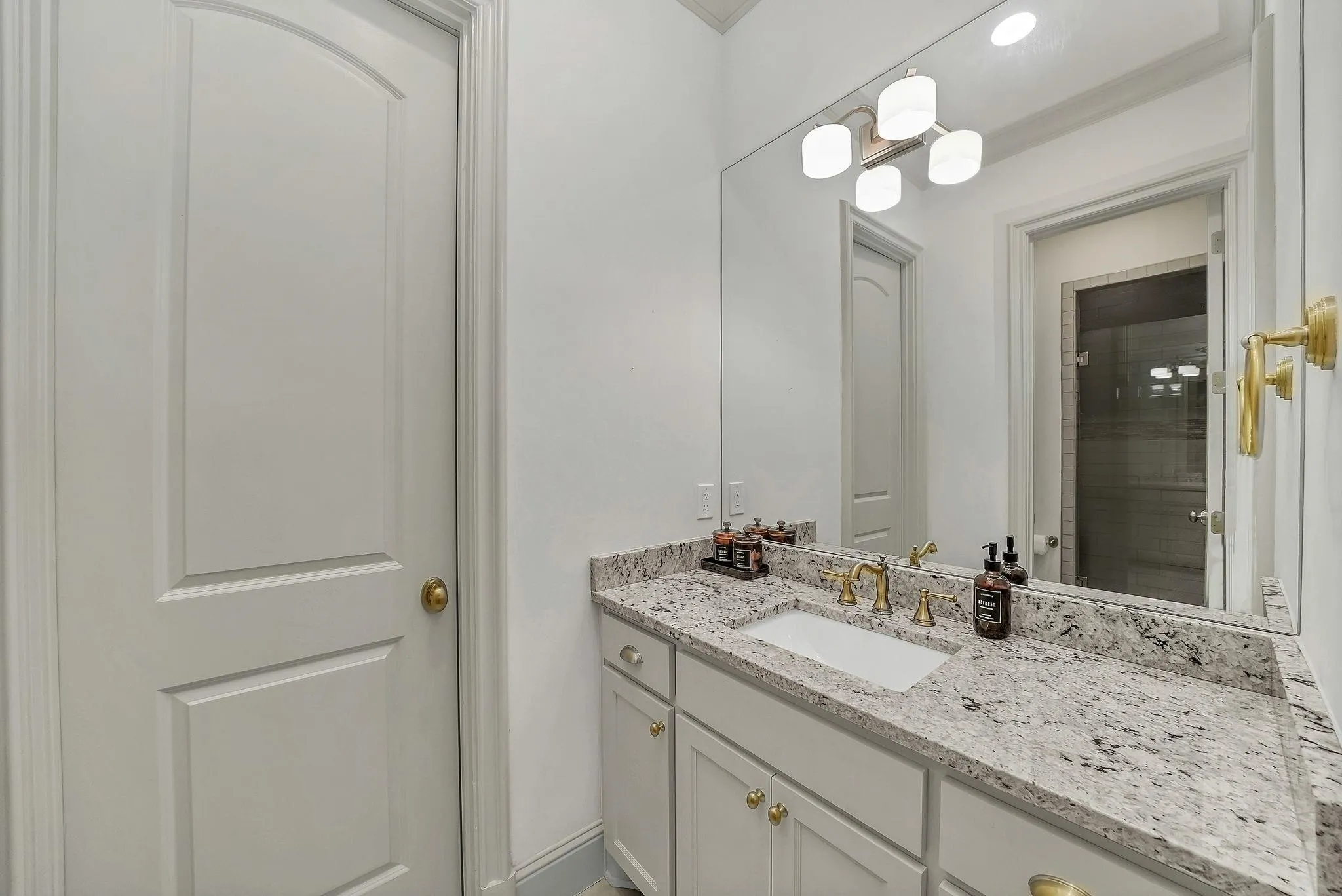 Vanity with a light-toned granite countertop and an undermount sink