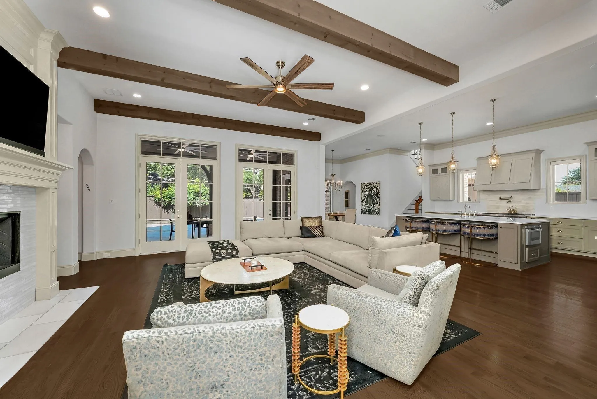 Spacious living area featuring exposed ceiling beams, recessed lighting, and rich wood-finish flooring