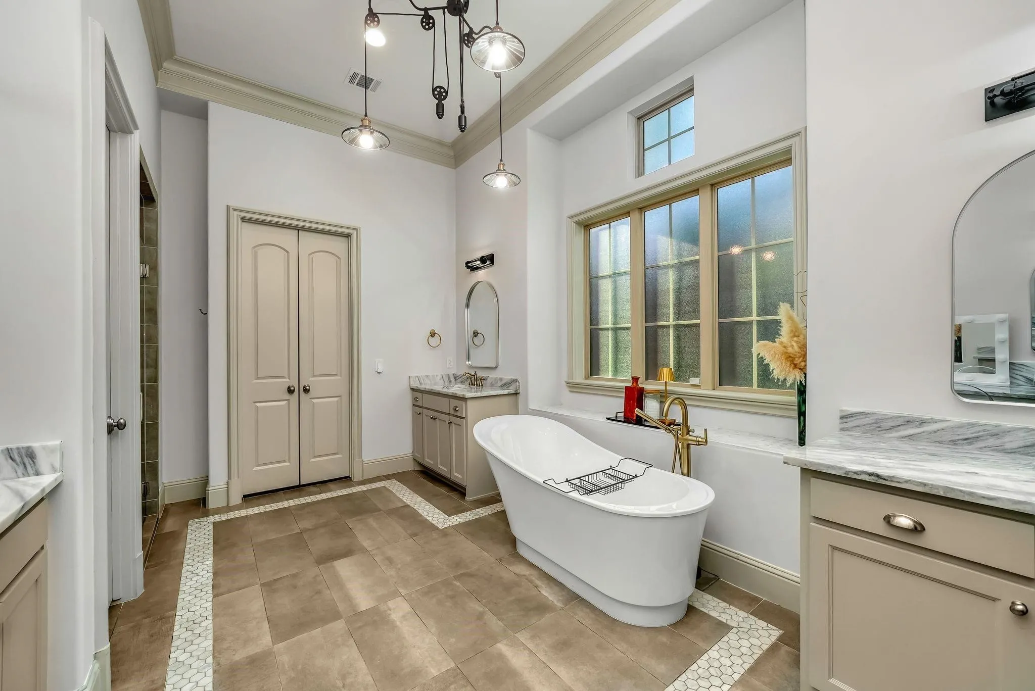 Freestanding soaking tub featuring a brass-finish floor-mounted faucet