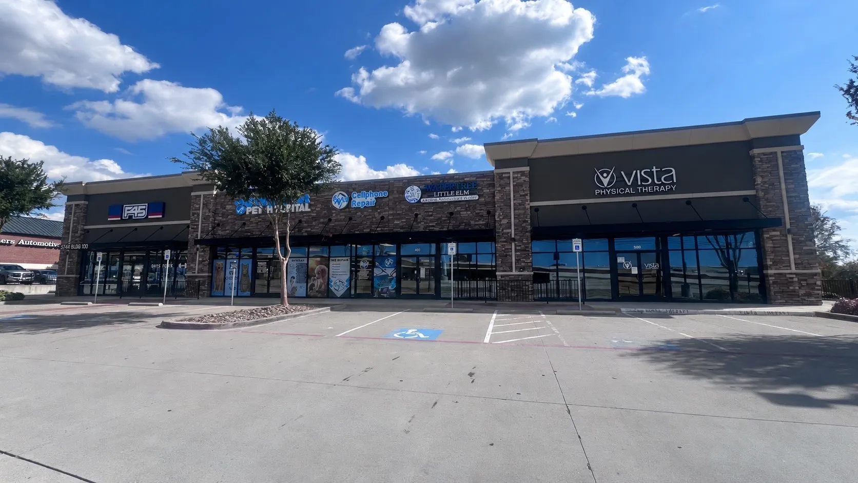 Commercial storefronts with stone accents, expansive glass windows, and prominent signage