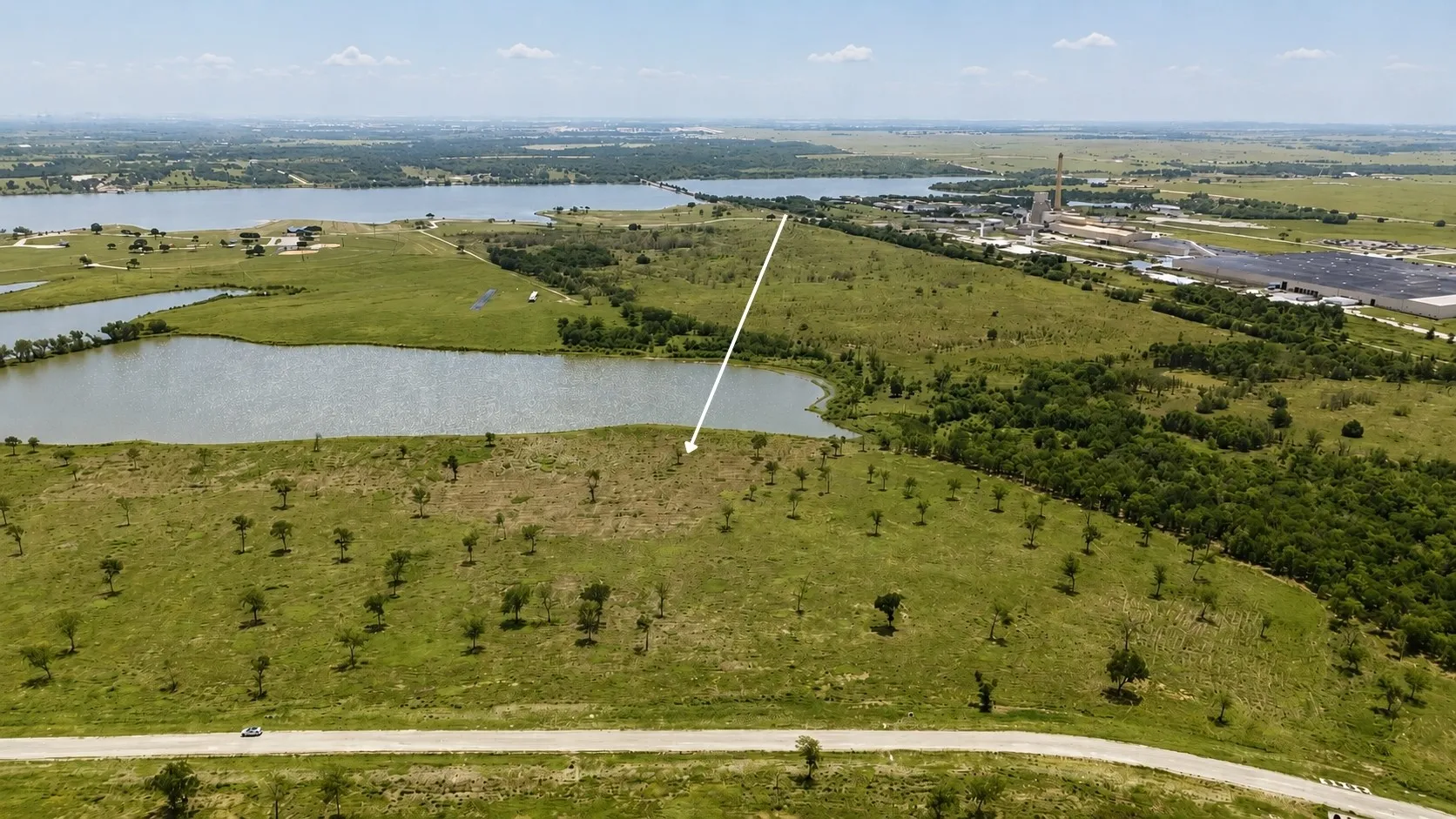 Bird's-eye view overlooking the homesite with water views and nearby community amenities.