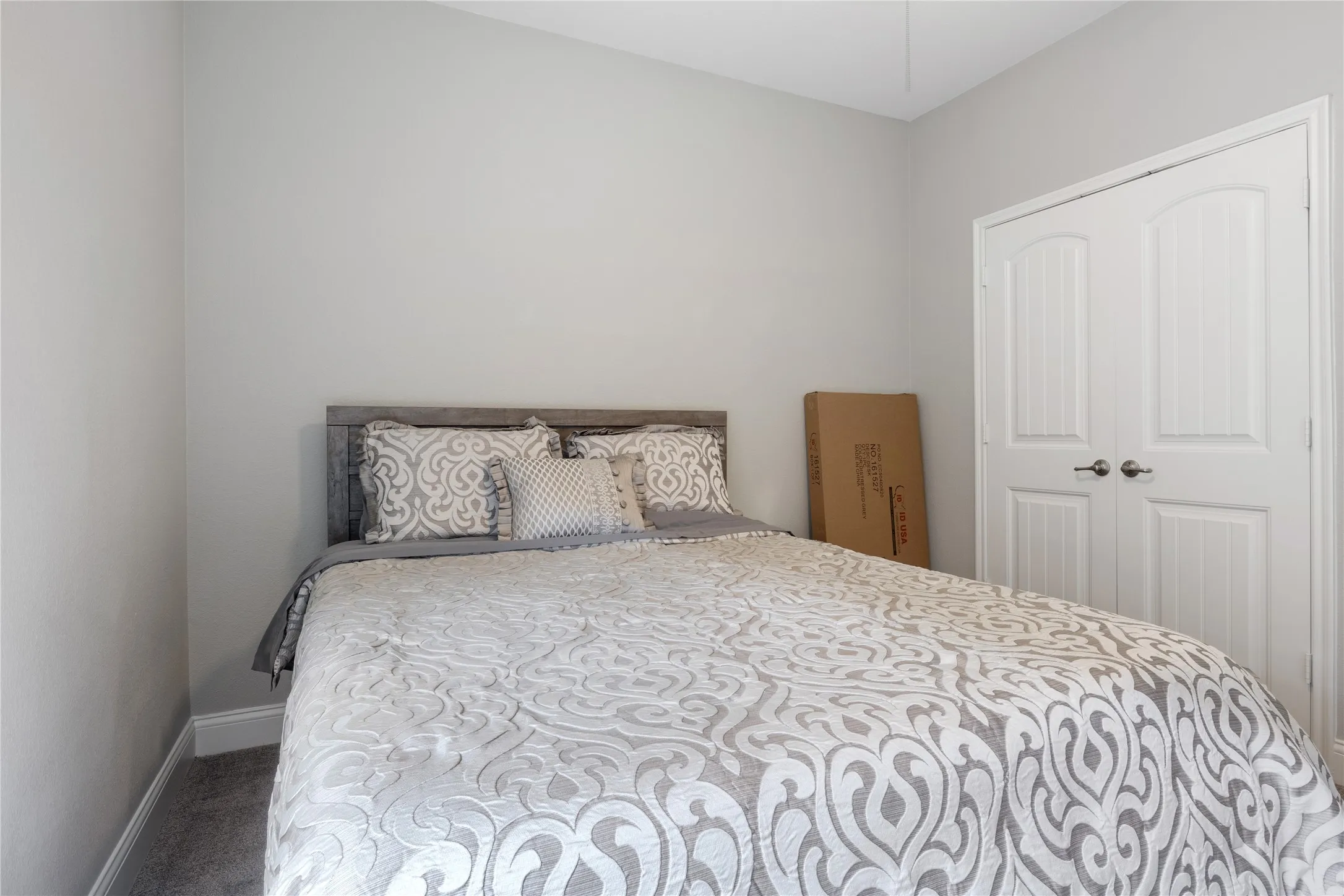 Bedroom featuring light gray walls, gray carpeting, and white baseboards