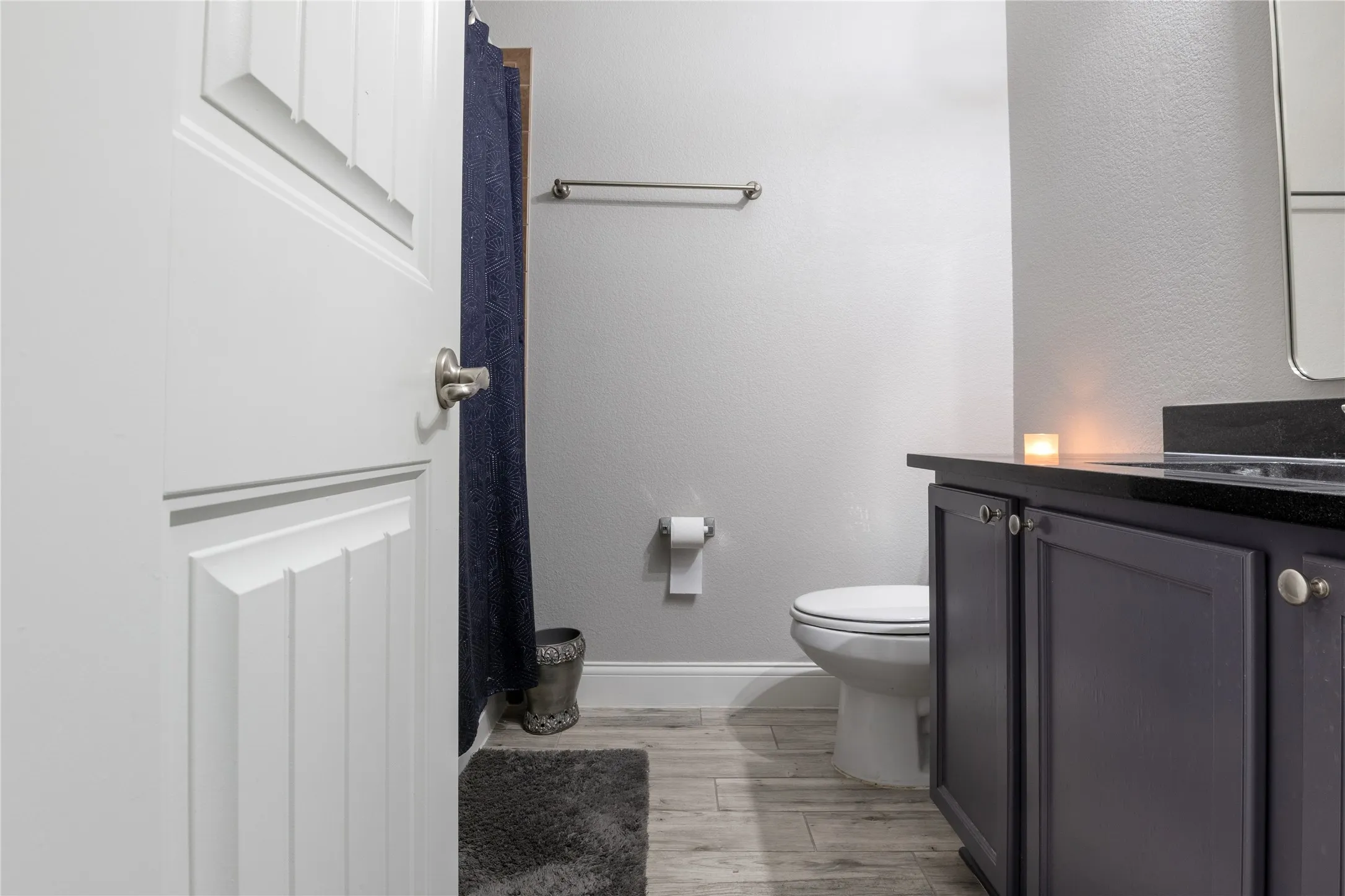 Bathroom vanity with dark cabinetry and a black countertop
