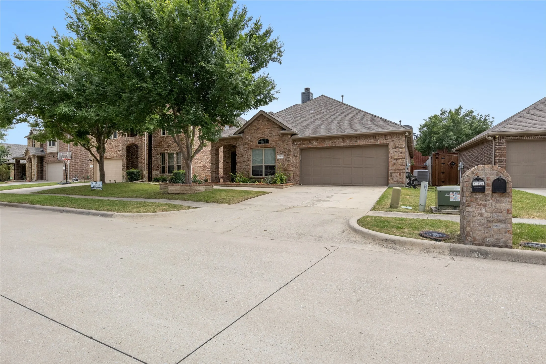Brick exterior residence featuring an attached garage and a concrete driveway