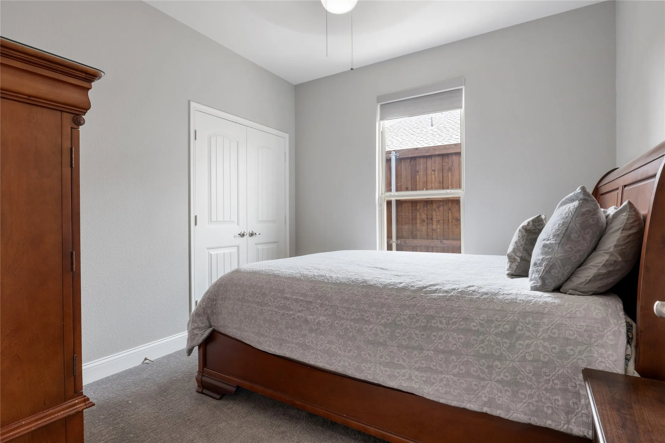 Bedroom featuring light gray walls, white baseboards, and gray carpet