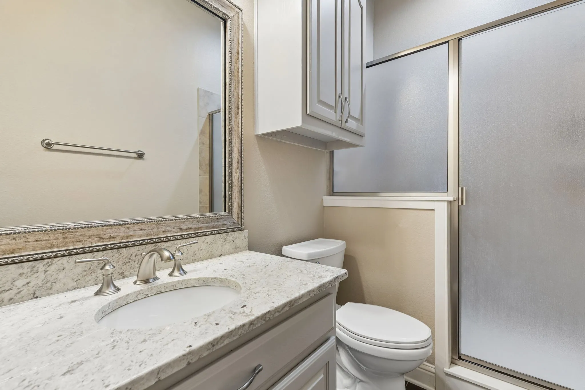 This full bath lives conveniently between the 3rd secondary bedroom and the media room for easy access! This bath boasts granite countertops, framed mirror and a large walk-in shower.
