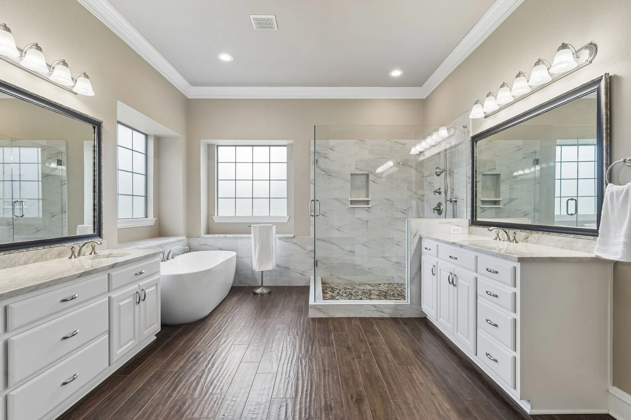 As you enter the home you will see the spacious formal dining room, featuring heavy crown molding, tray ceilings, tile floors with a wood look and a decorative light.