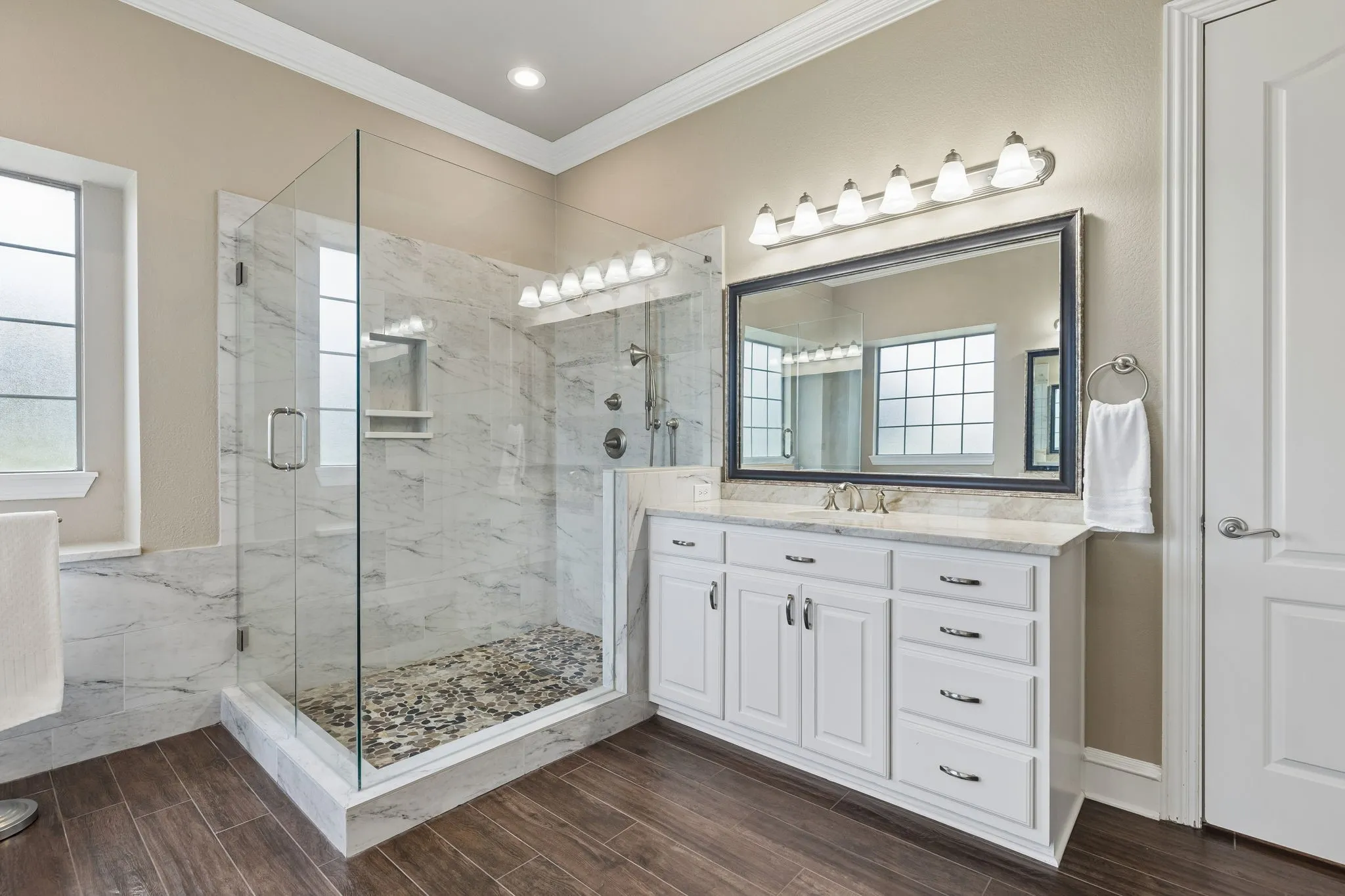 The vanities in this primary bath offer ample storage along with a large linen closet.