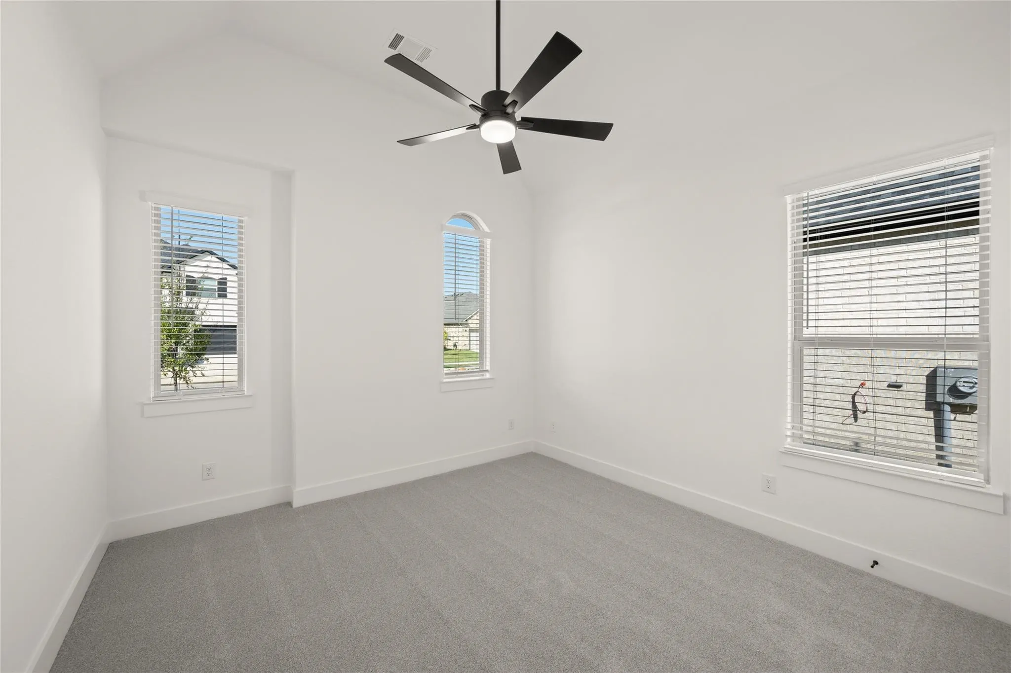 Spare room with carpet floors, lofted ceiling, and ceiling fan