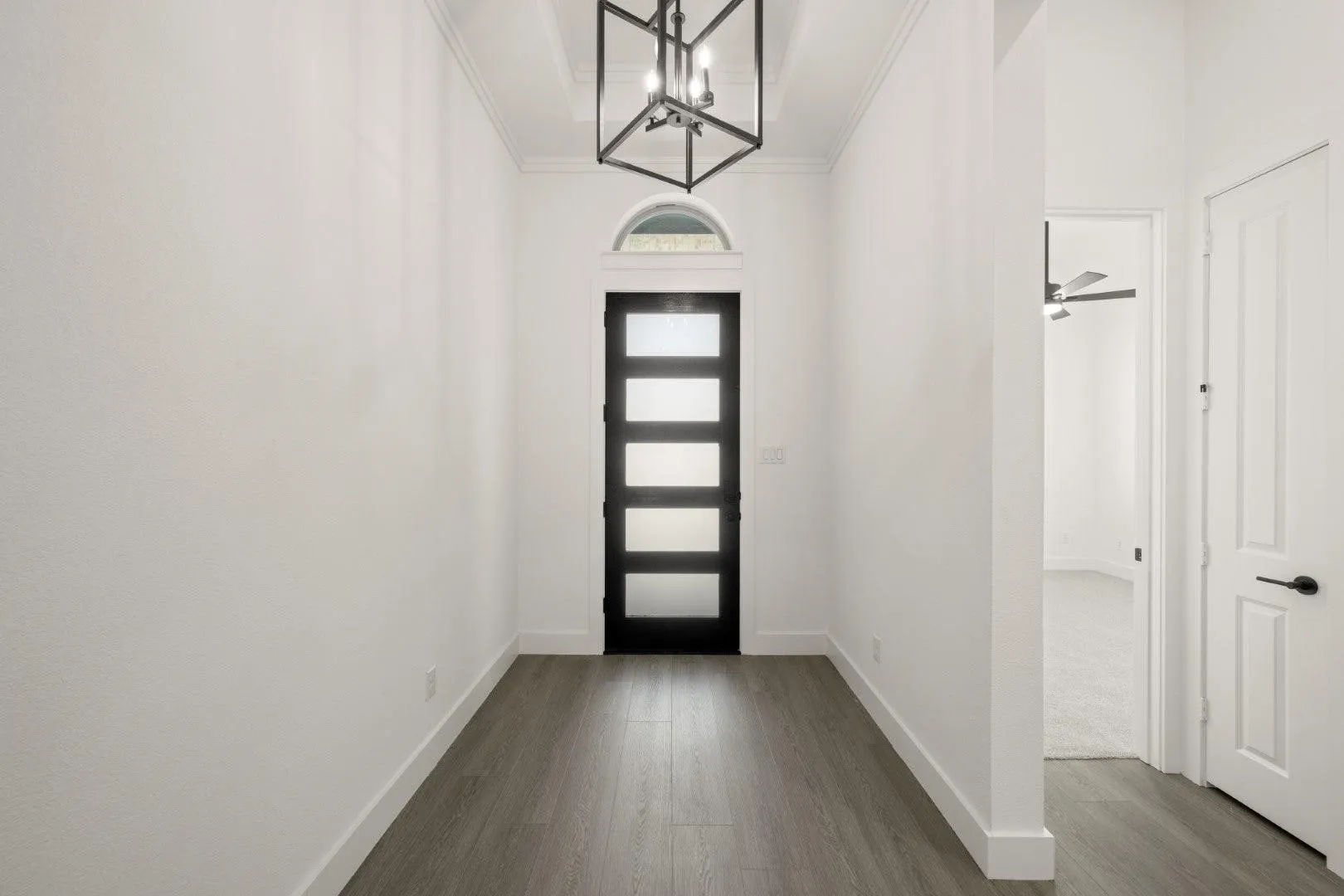 Foyer entrance featuring dark wood-style floors, a chandelier, ornamental molding, and ceiling fan