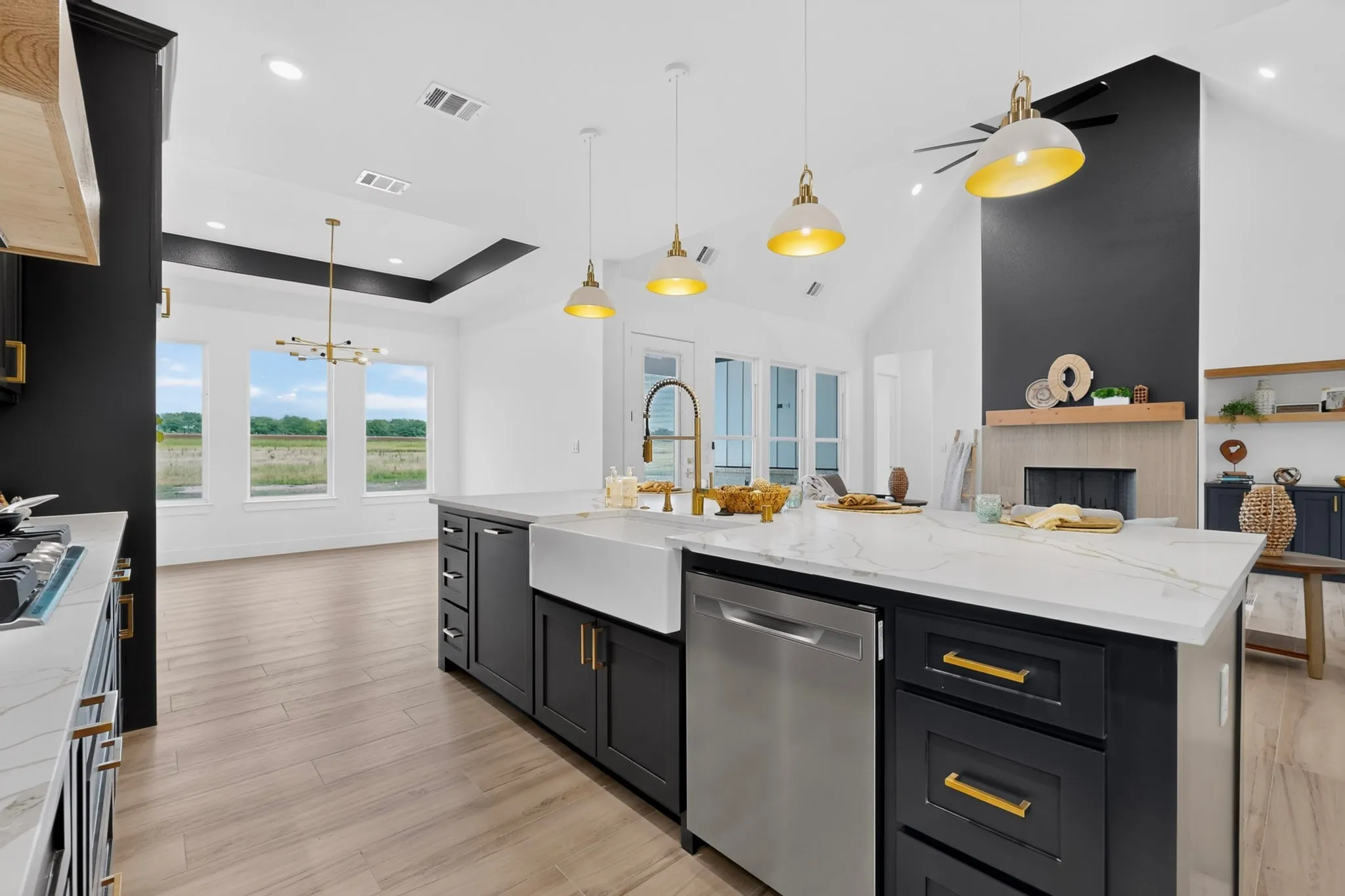 Spacious kitchen island featuring a farmhouse sink, stainless steel dishwasher, and pendant lighting