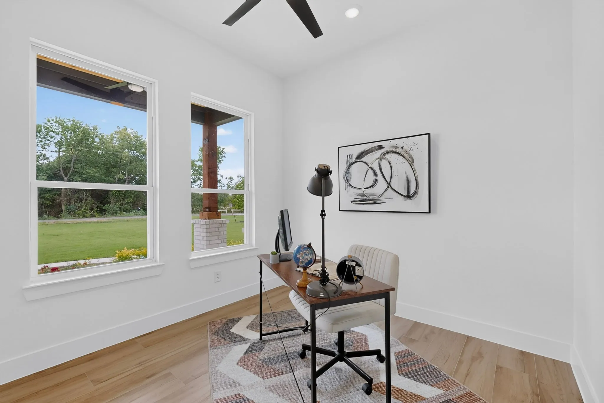 Spacious room featuring two large windows, wood-finish flooring, a ceiling fan, and recessed lighting