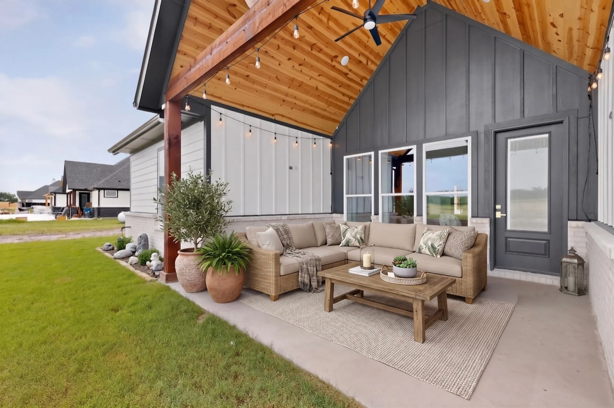 Covered patio featuring a sloped wood-finish ceiling with exposed beams, a ceiling fan, and string lighting