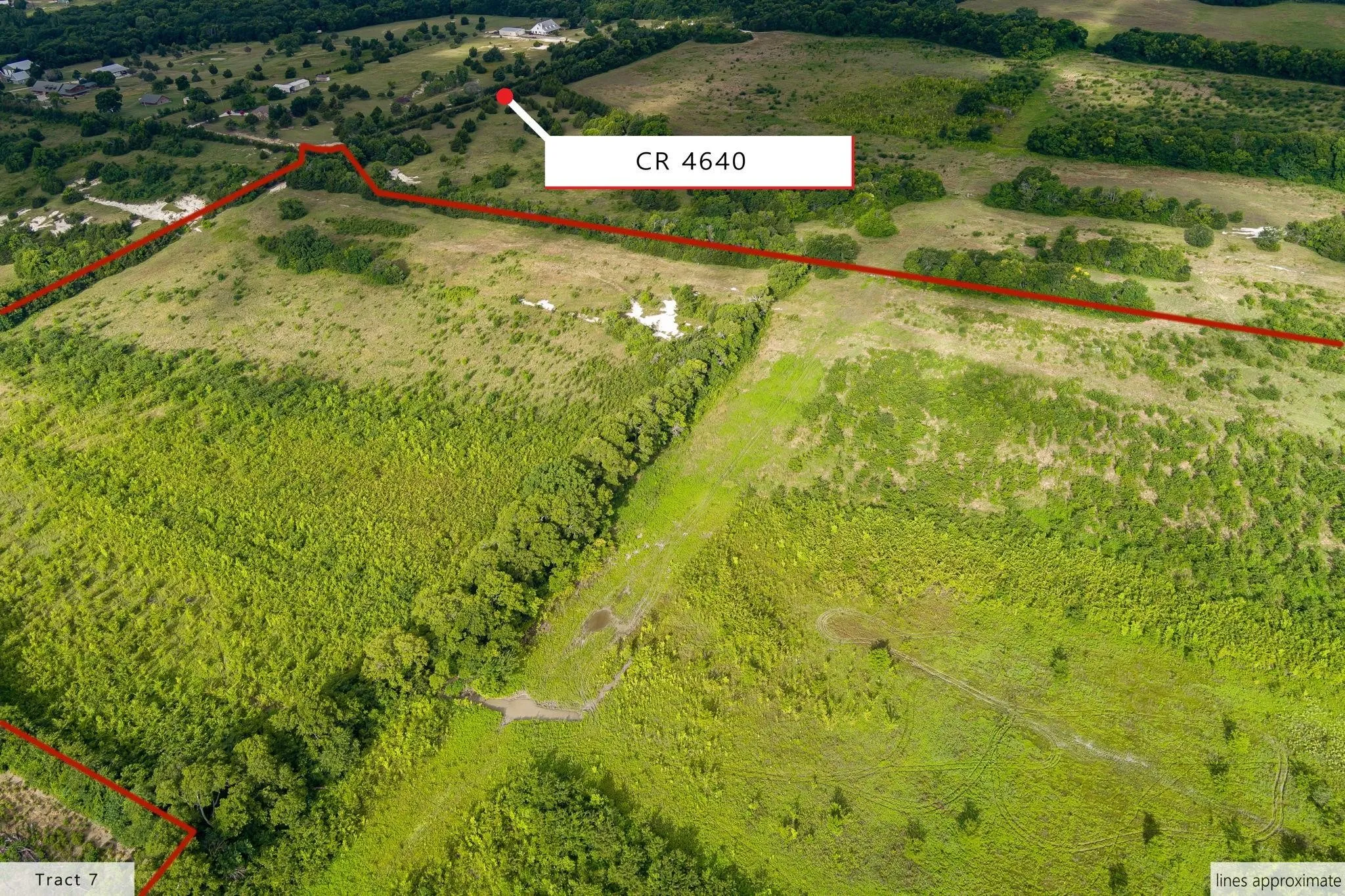 Expansive land parcel featuring varied terrain including open fields and wooded areas