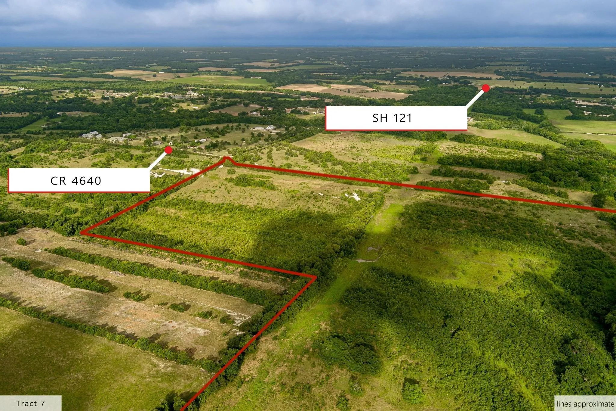 Expansive aerial view of a verdant land parcel, outlined in red, featuring varied terrain and abundant tree coverage