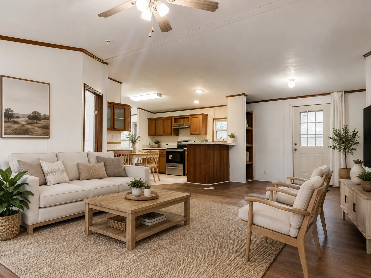 Expansive living area with wood-finish flooring, a ceiling fan, and built-in shelving