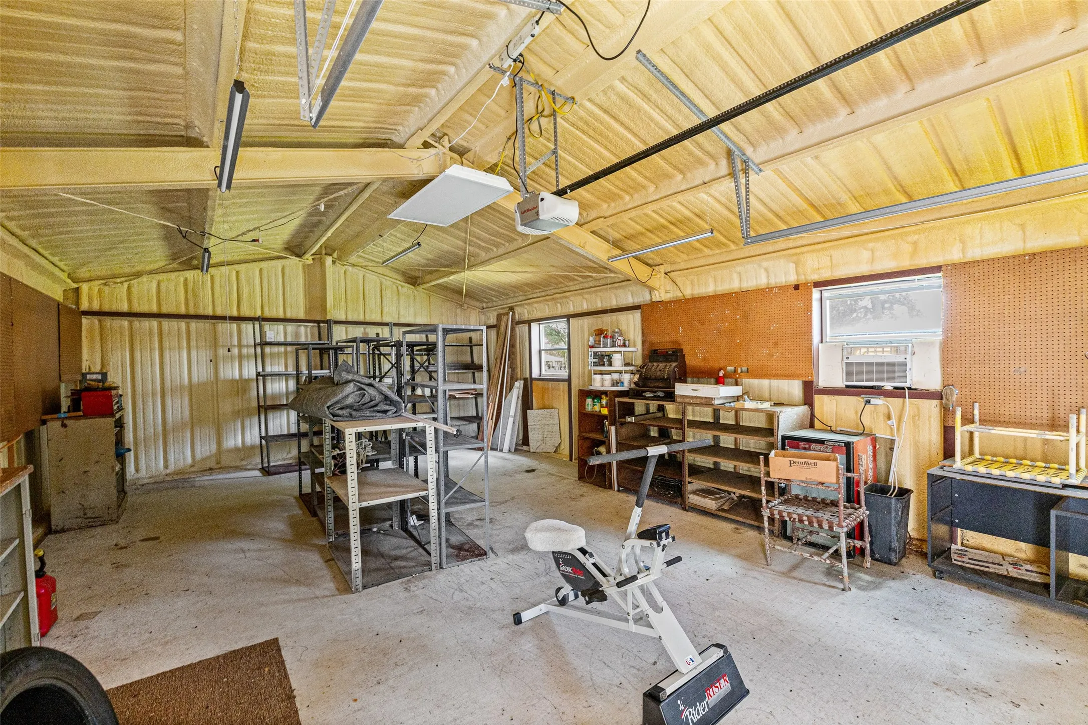 The large yellow workshop interior. Blown in insulation keeps it cool. Has large roll up door as well.