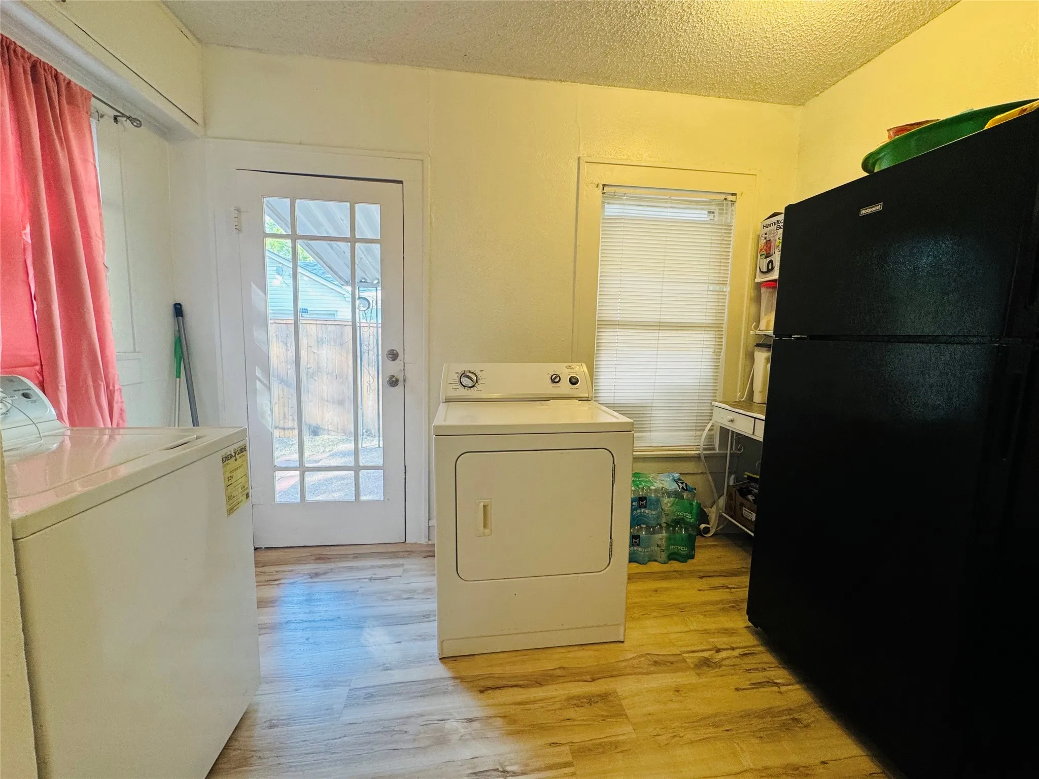 Utility area featuring wood-finish flooring and a multi-pane glass panel door